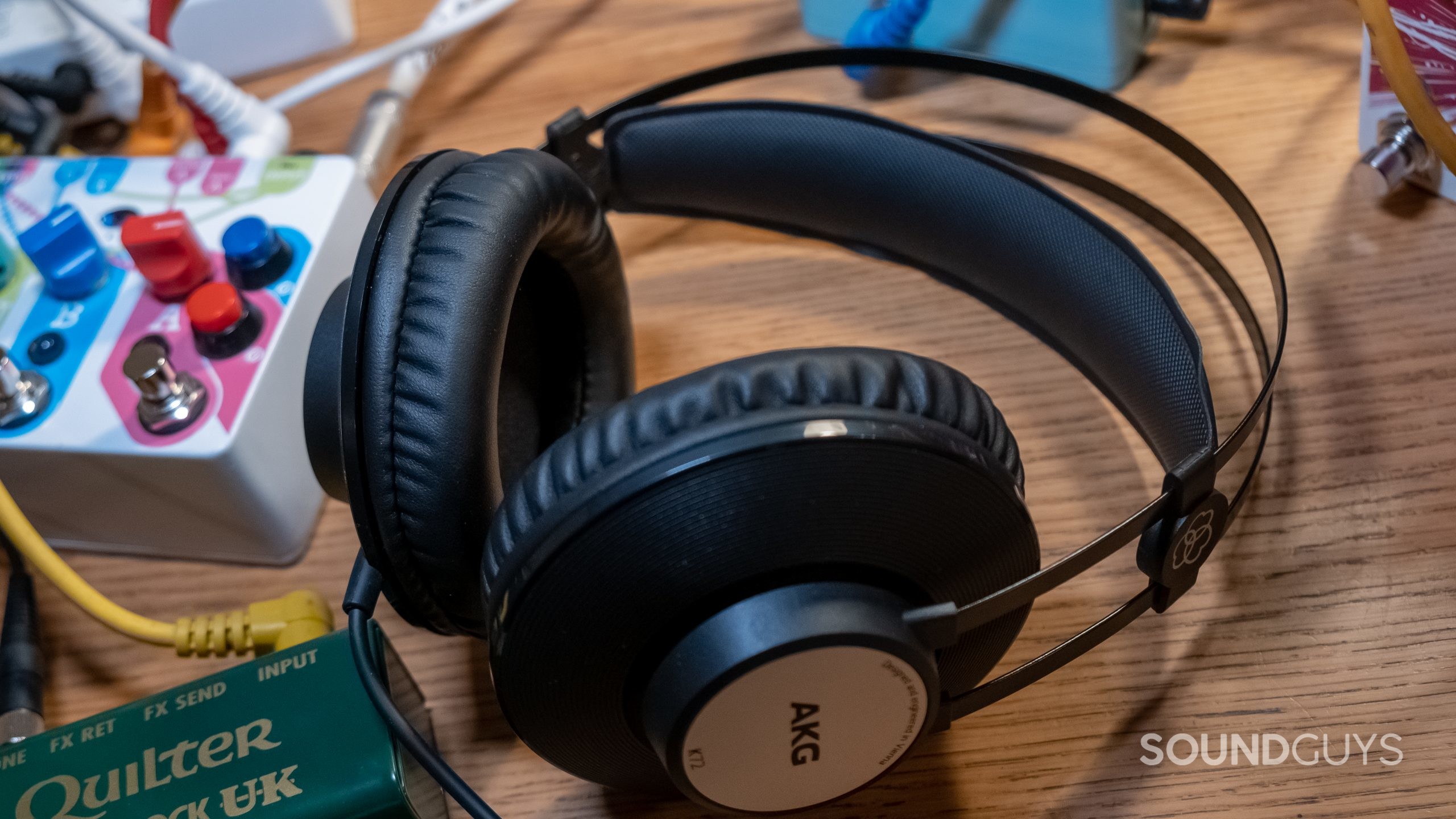 The AKG K72 rests on a wood desk surrounded by music equipment.