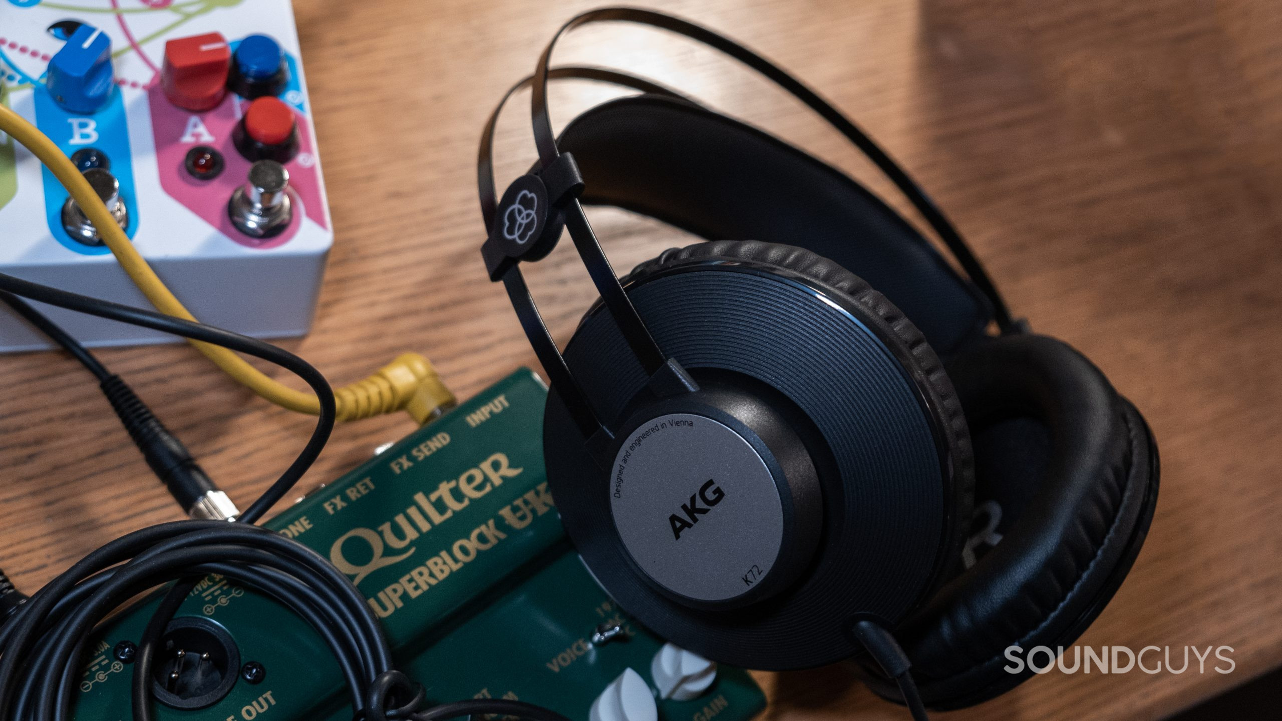 The AKG K72 rests on a desk and mini amp.