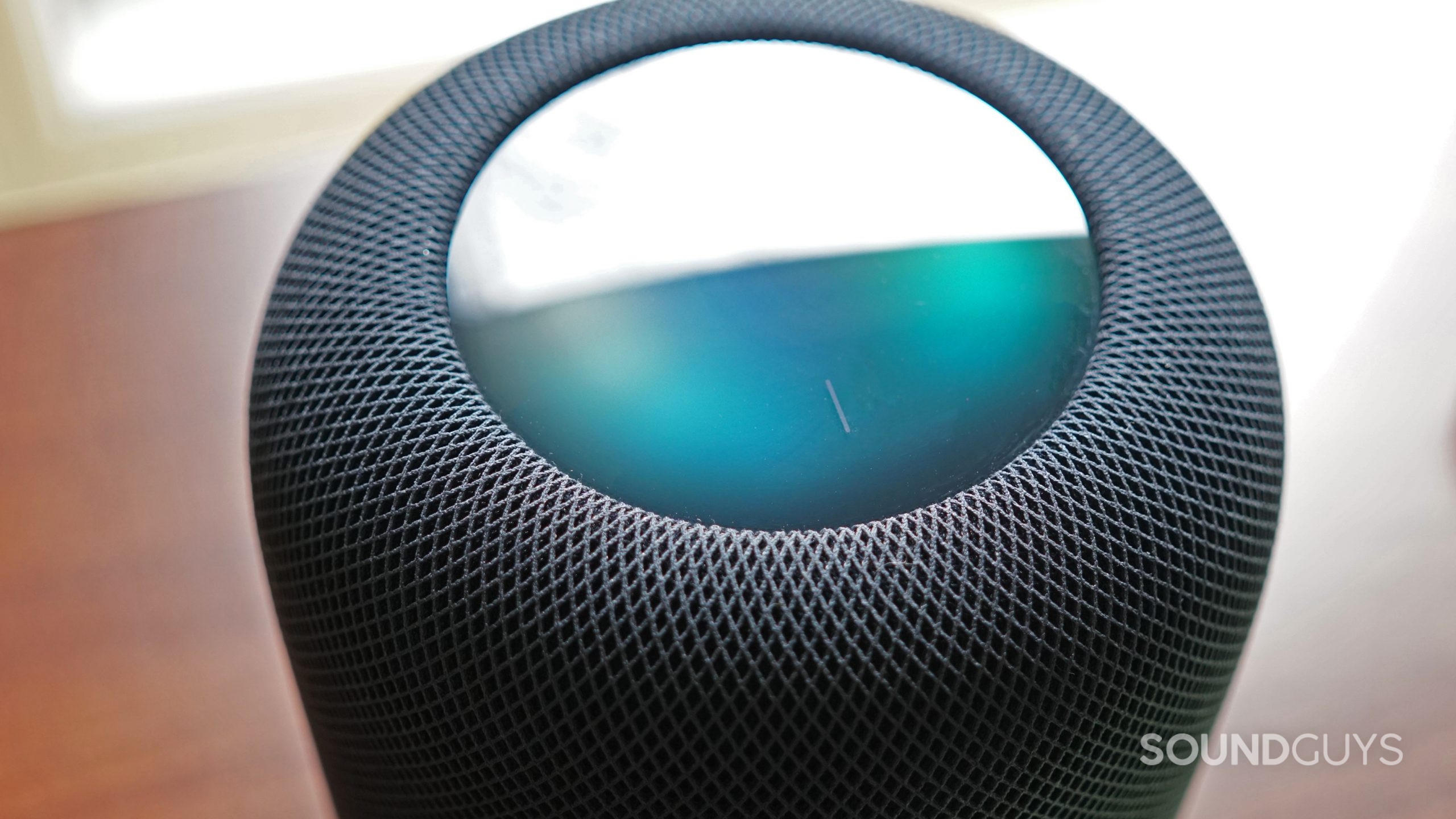A closeup shot of the Apple HomePod (2nd Generation) touch display shows colors as it plays music.