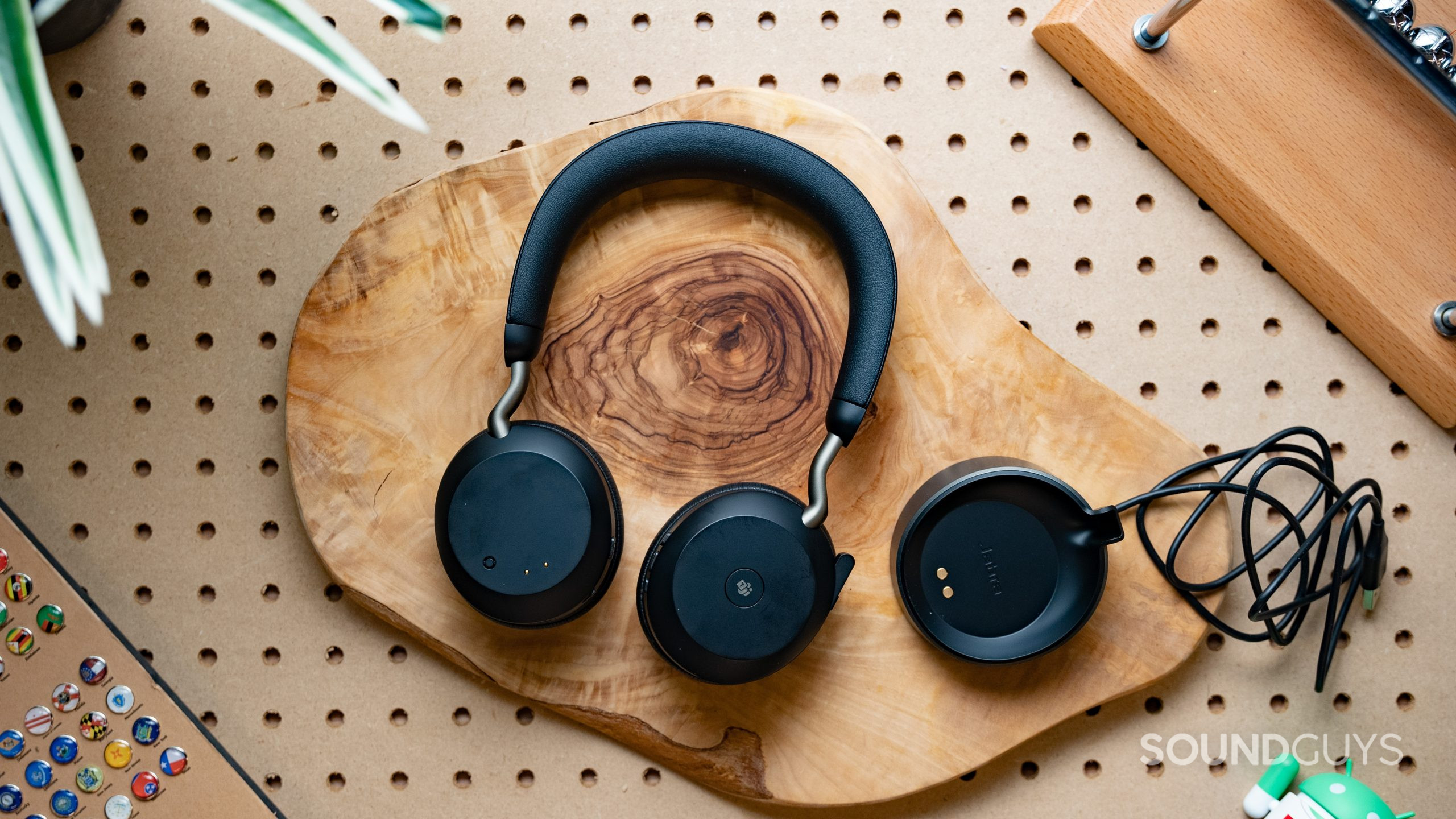 The Jabra Evolve2 75 sitting on a table next to its charging cradle.