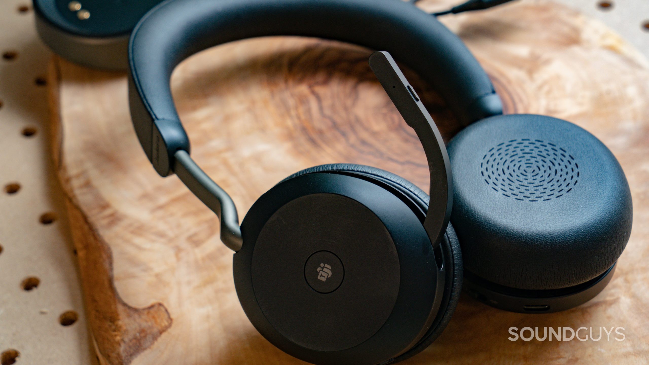 The Jabra Evolve2 75 sitting on a wooden tabletop with one earcup facing the viewer.