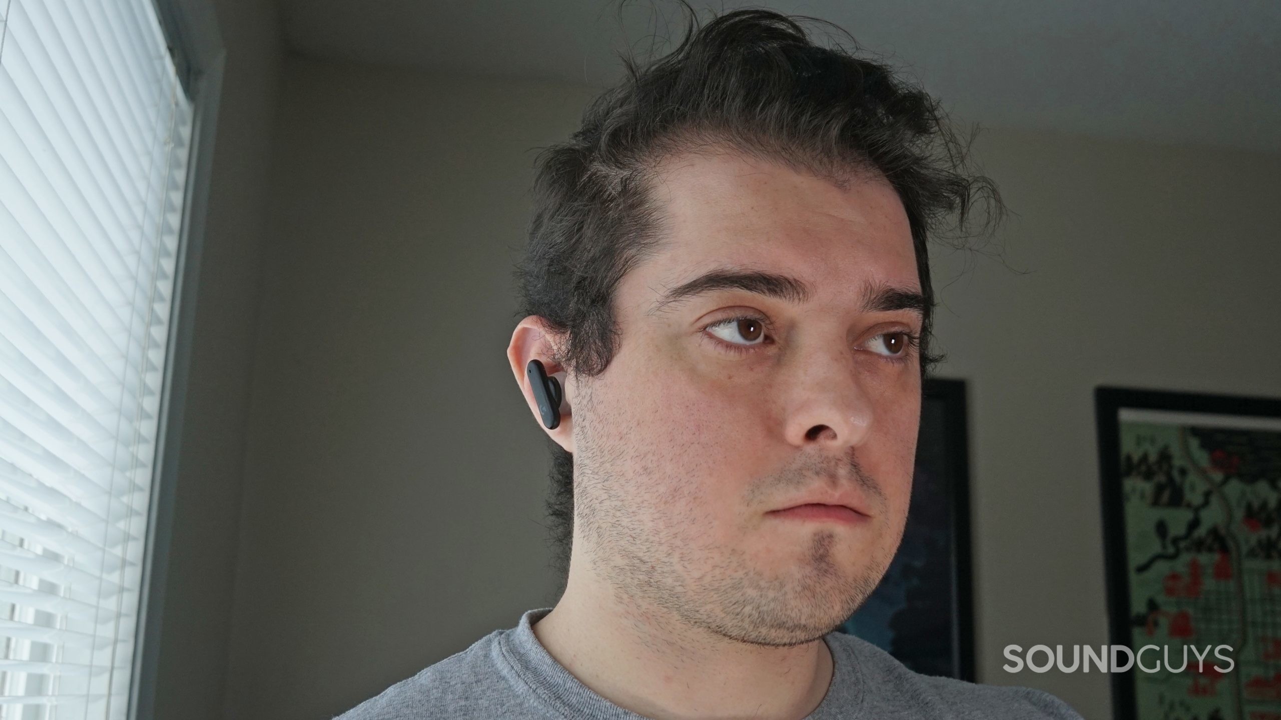 A man wears the Logitech G Fits earbuds.