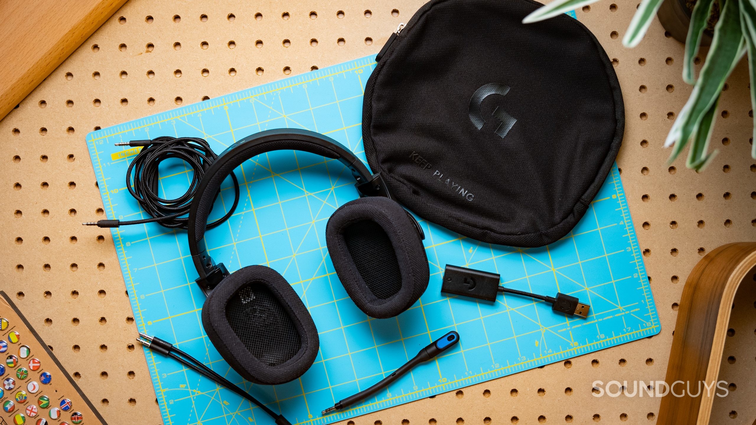 The Logitech G433 sitting on a wooden surface surrounded by all the accessories it comes with.