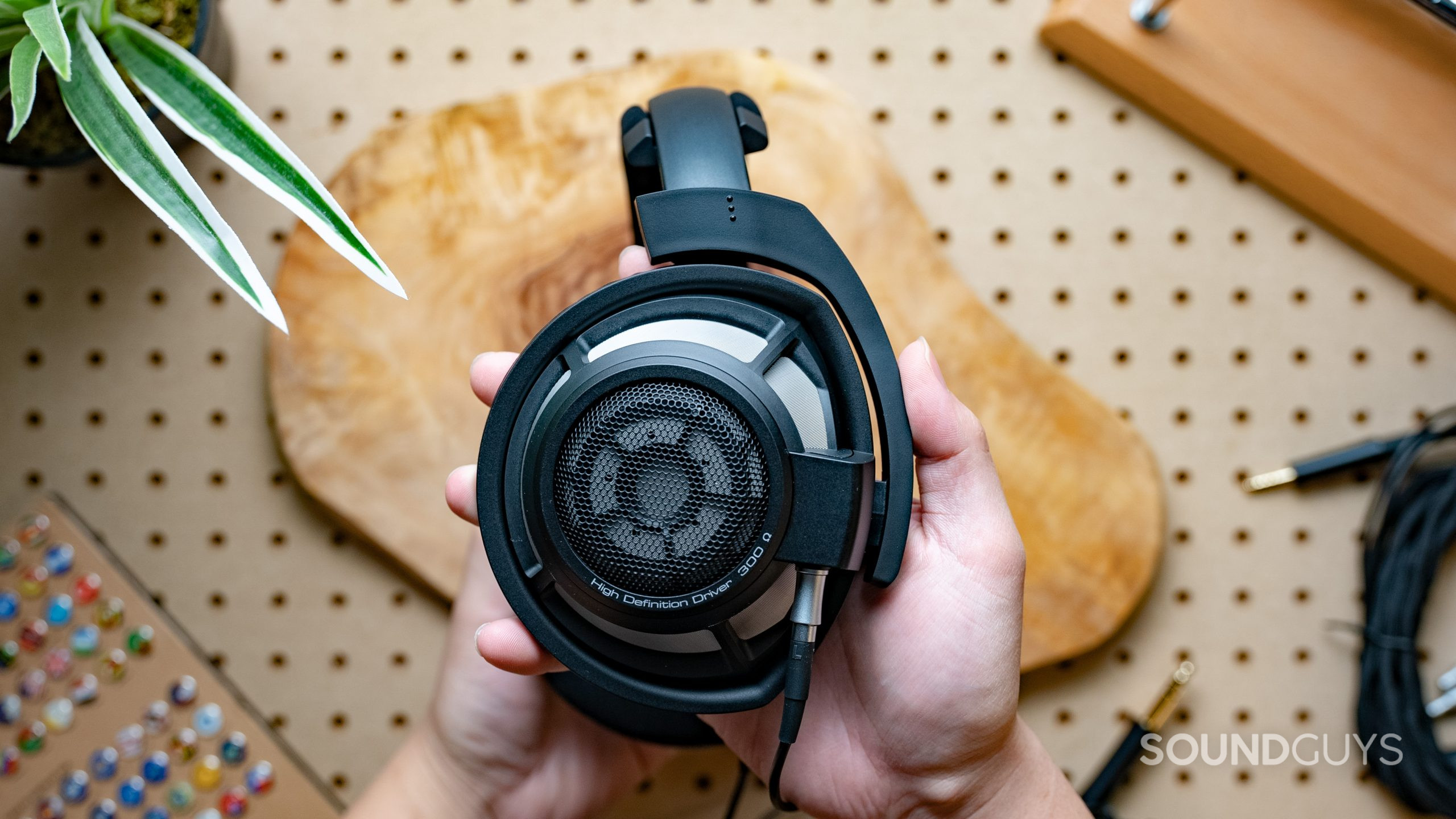 A photo of the Sennheiser HD 800 S being held in front of pegboard.