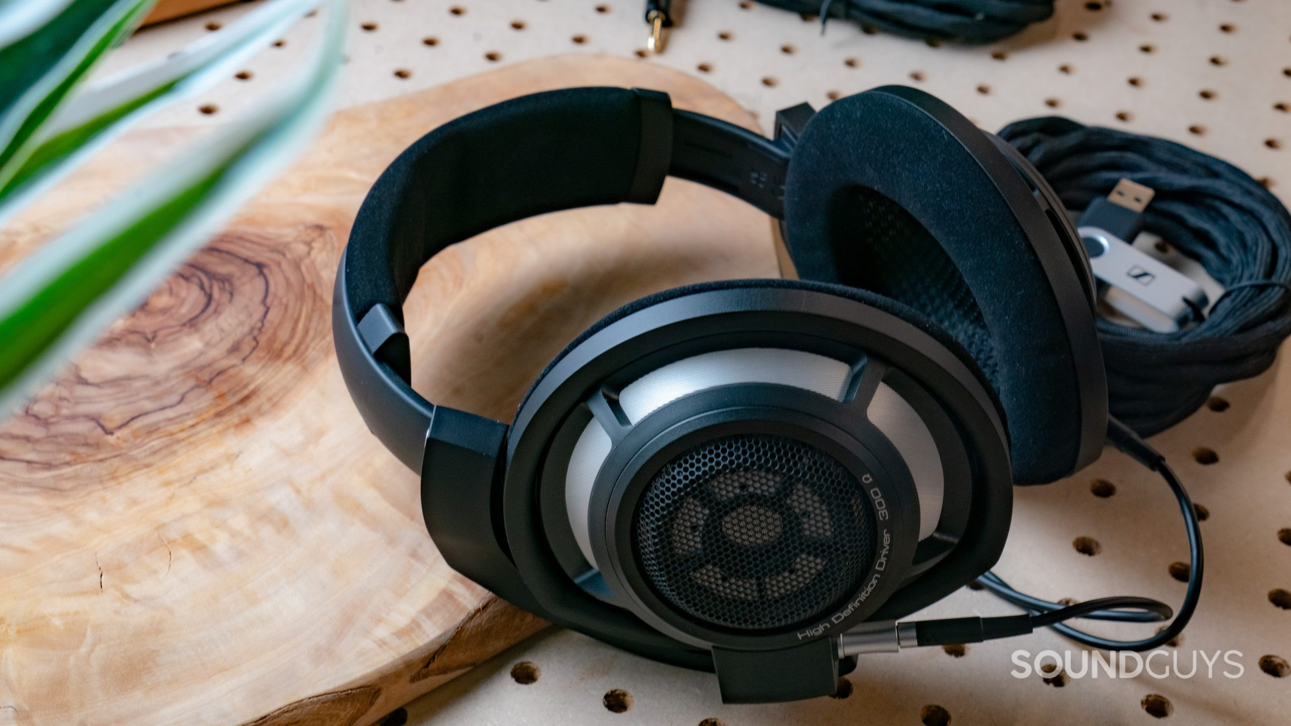 A photo of the Sennheiser HD 800 S lying atop a wood slab and pegboard.