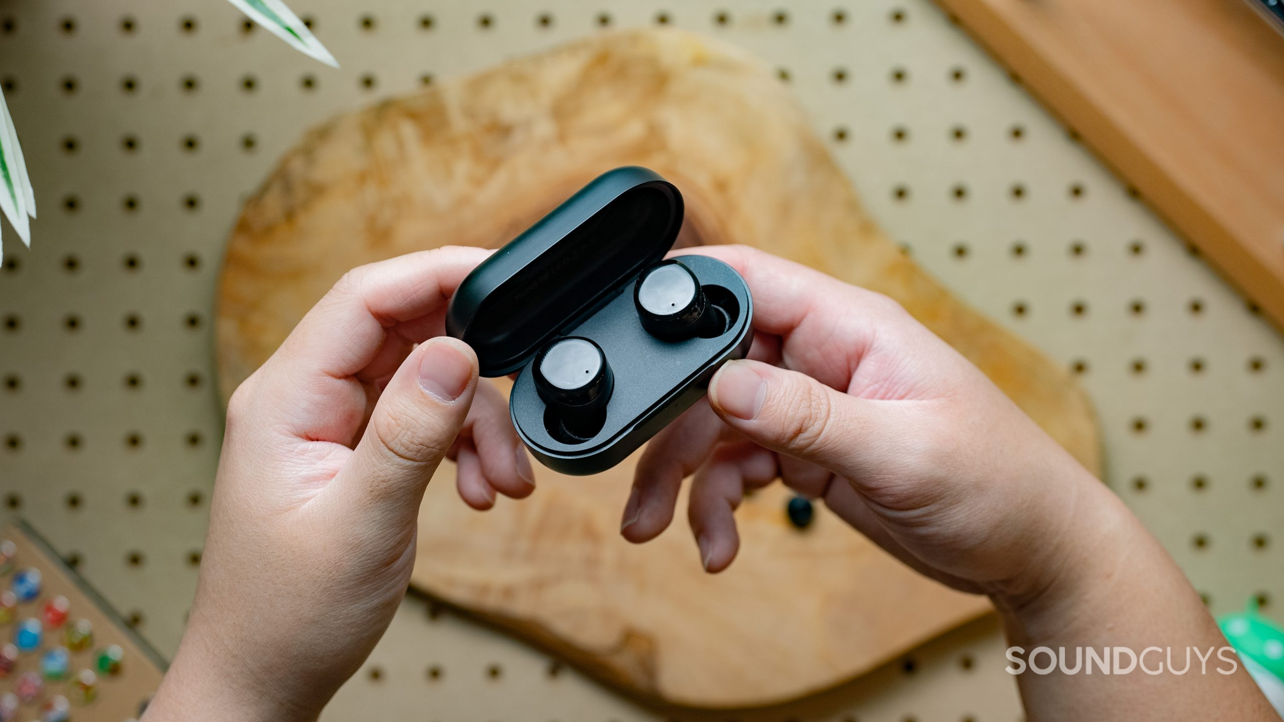 TOZO T12 earbuds being held by two hands