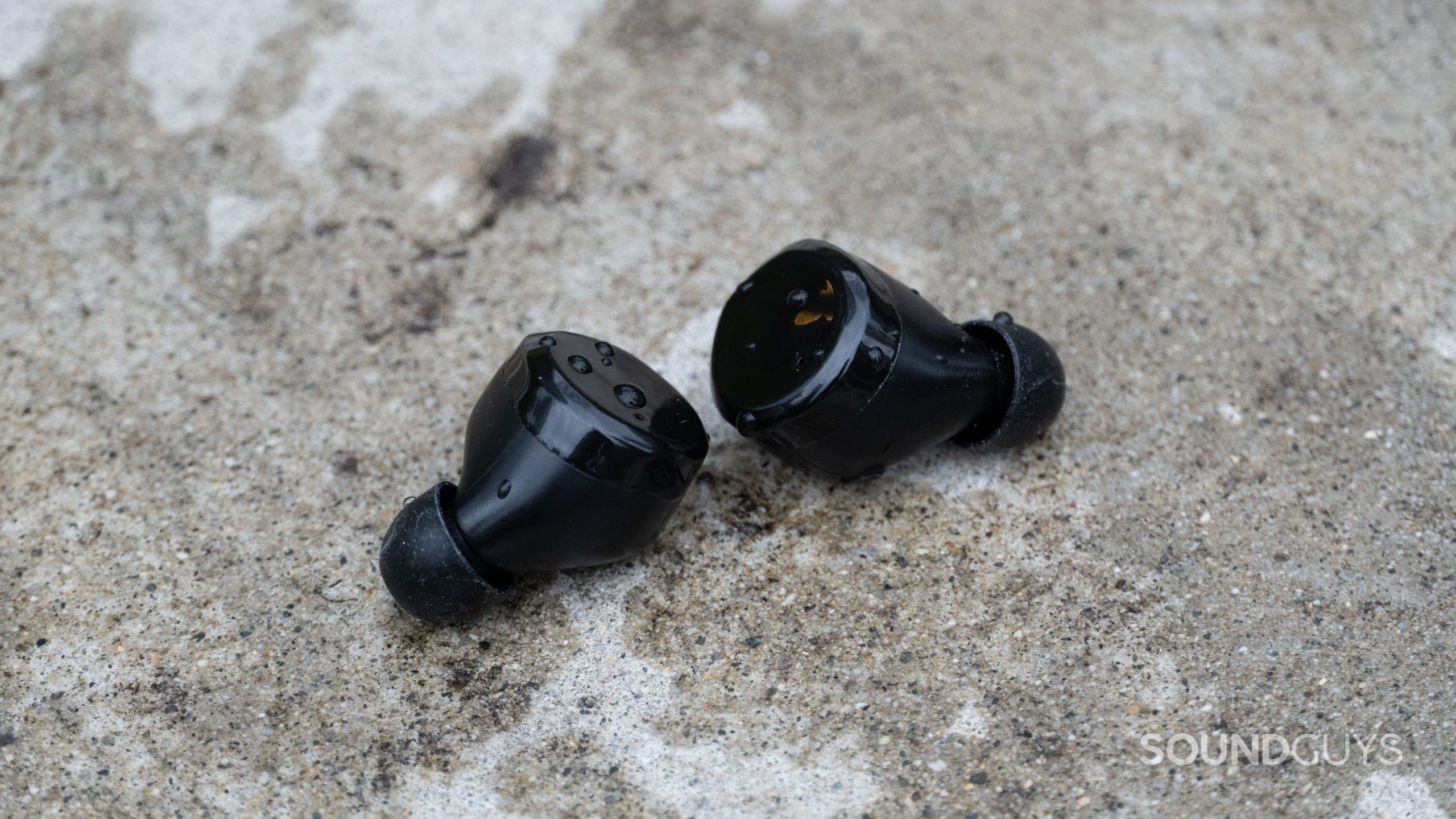 TOZO T12 earbuds outside with water splashed on the earbuds