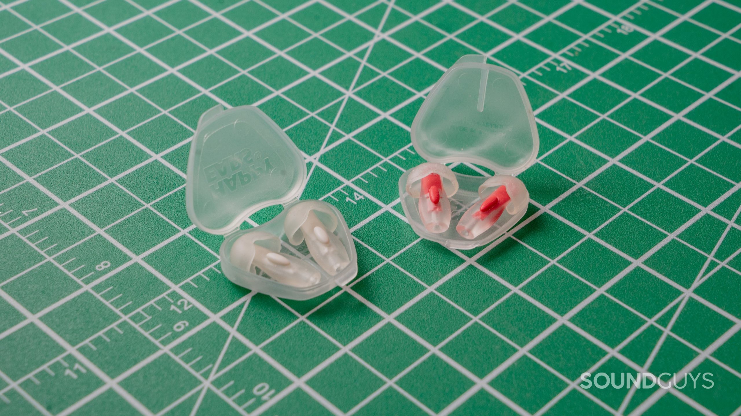Happy Ears earplugs in 2 sizes against a white on green grid background.