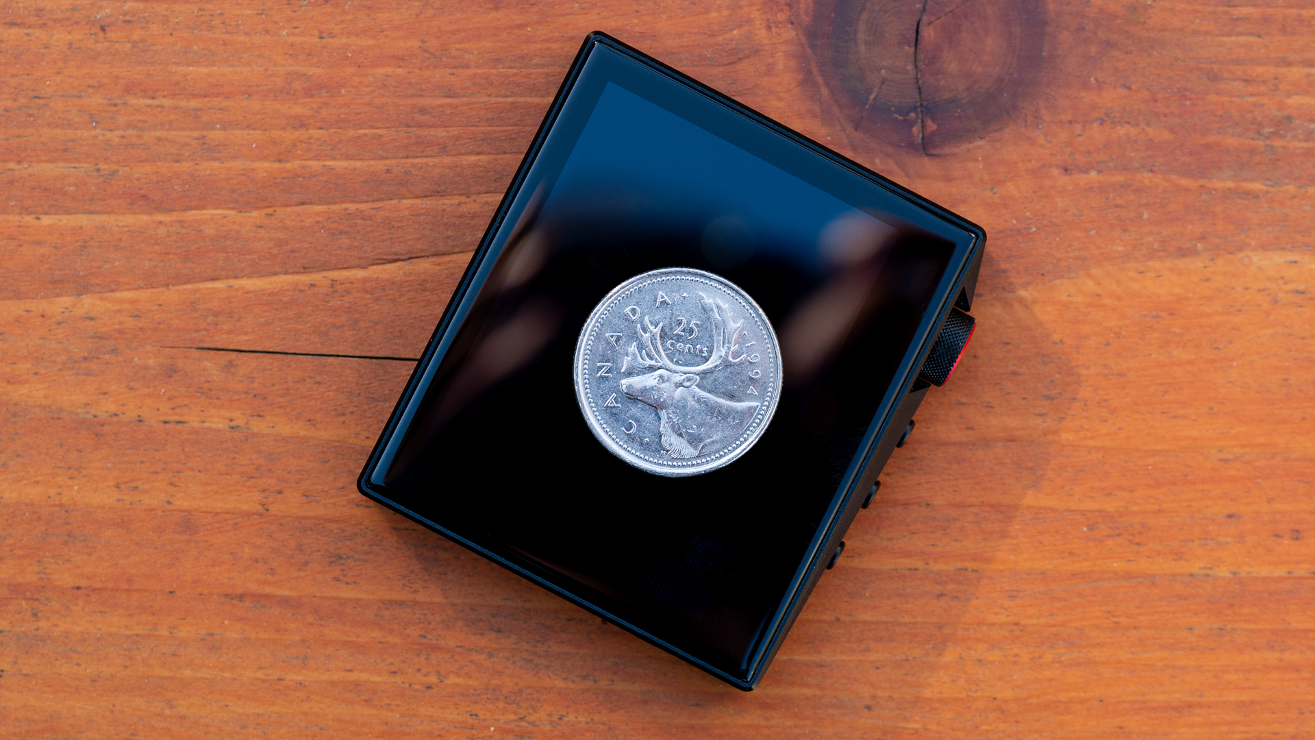 A photo of a Canadian quarter showing the size of the Hidisz AP80 Pro.