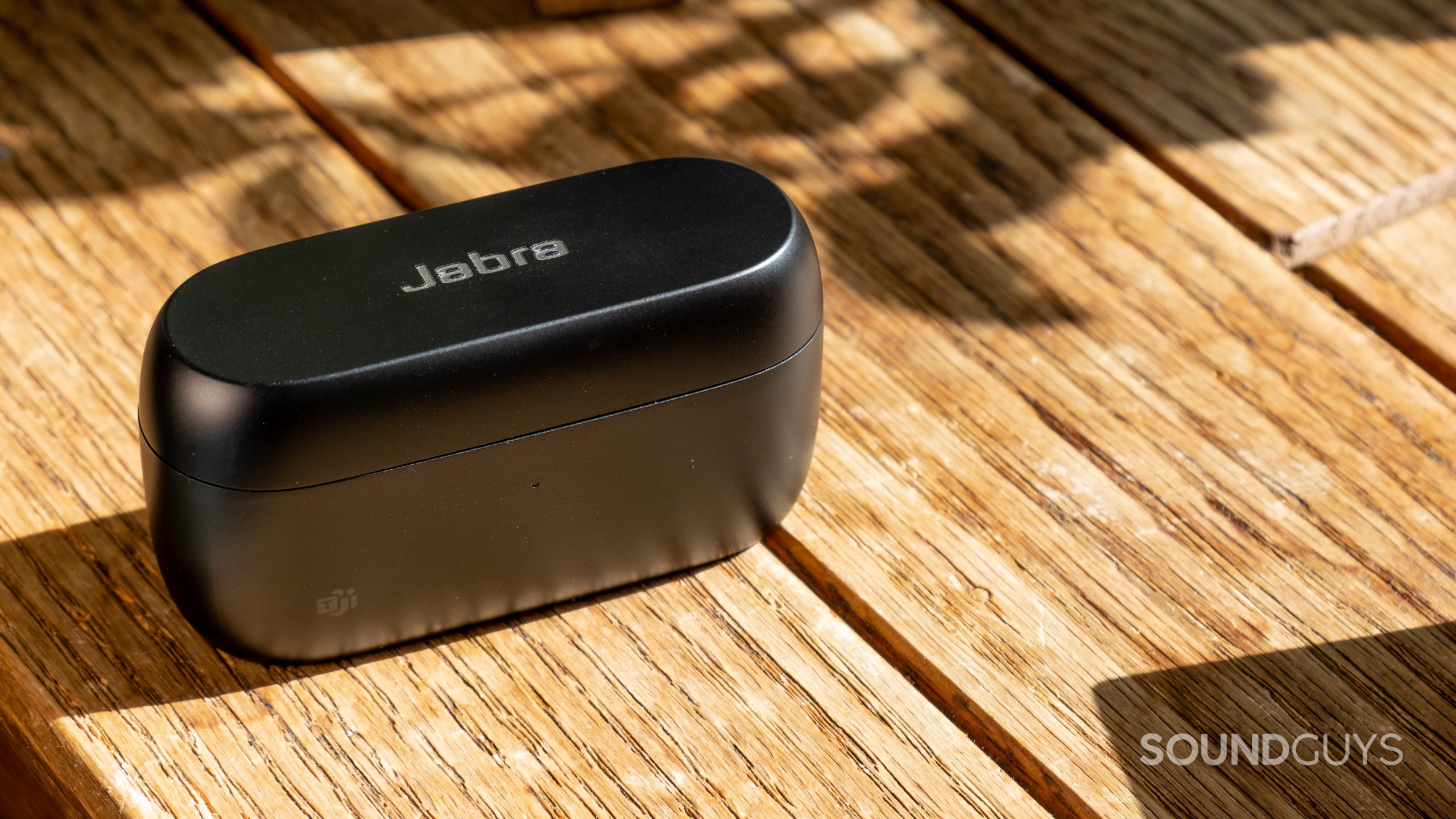 The Jabra Evolve2 Buds charging case shown closed on a wood surface.