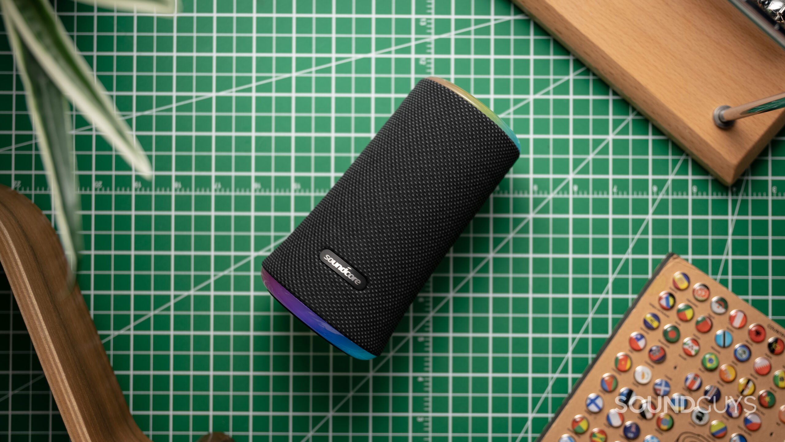 Anker Soundcore Flare 2 laying on a grid surrounded by various wood surfacess.