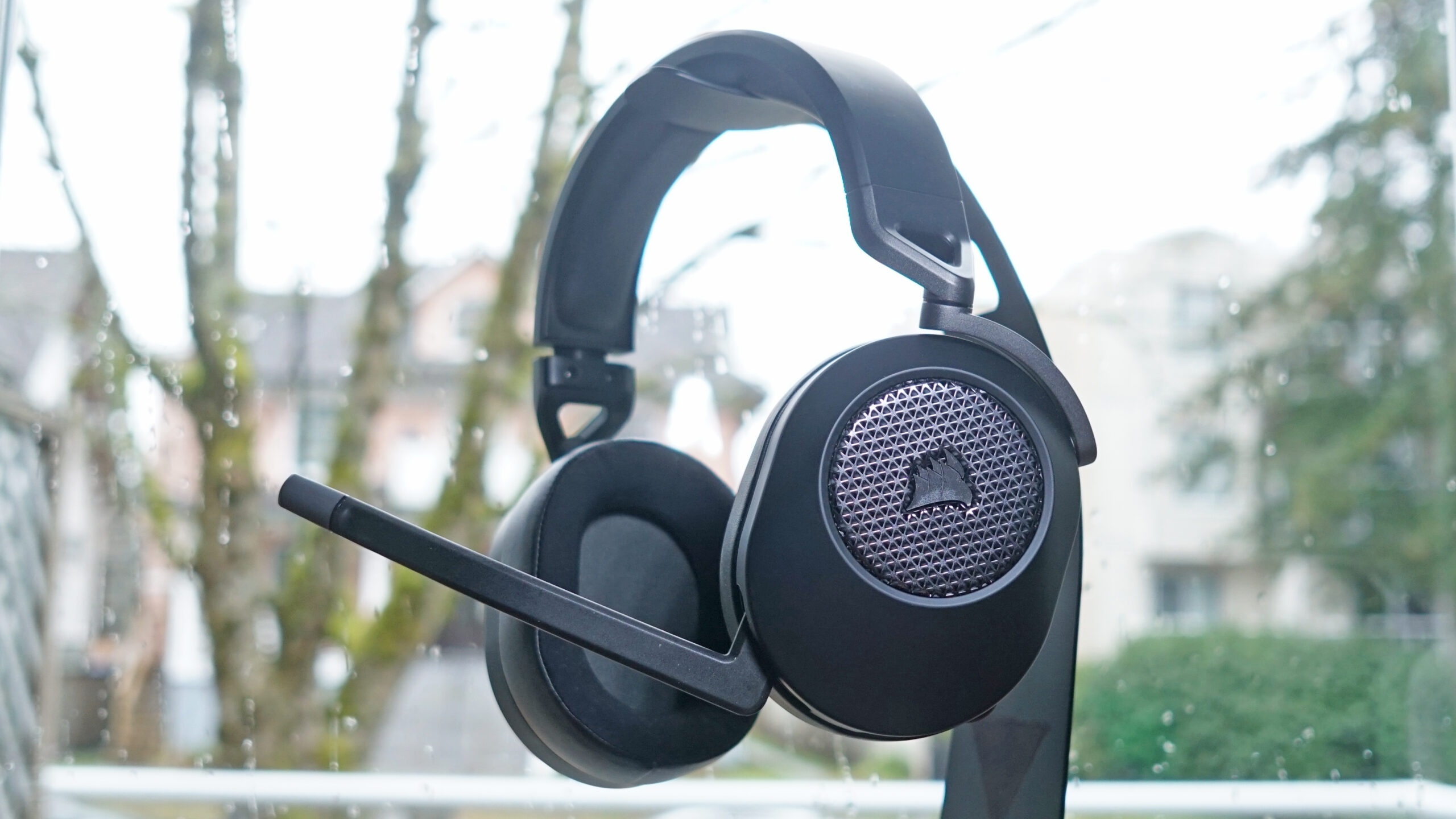 The Corsair HS65 Wireless hangs from a headphone stand.