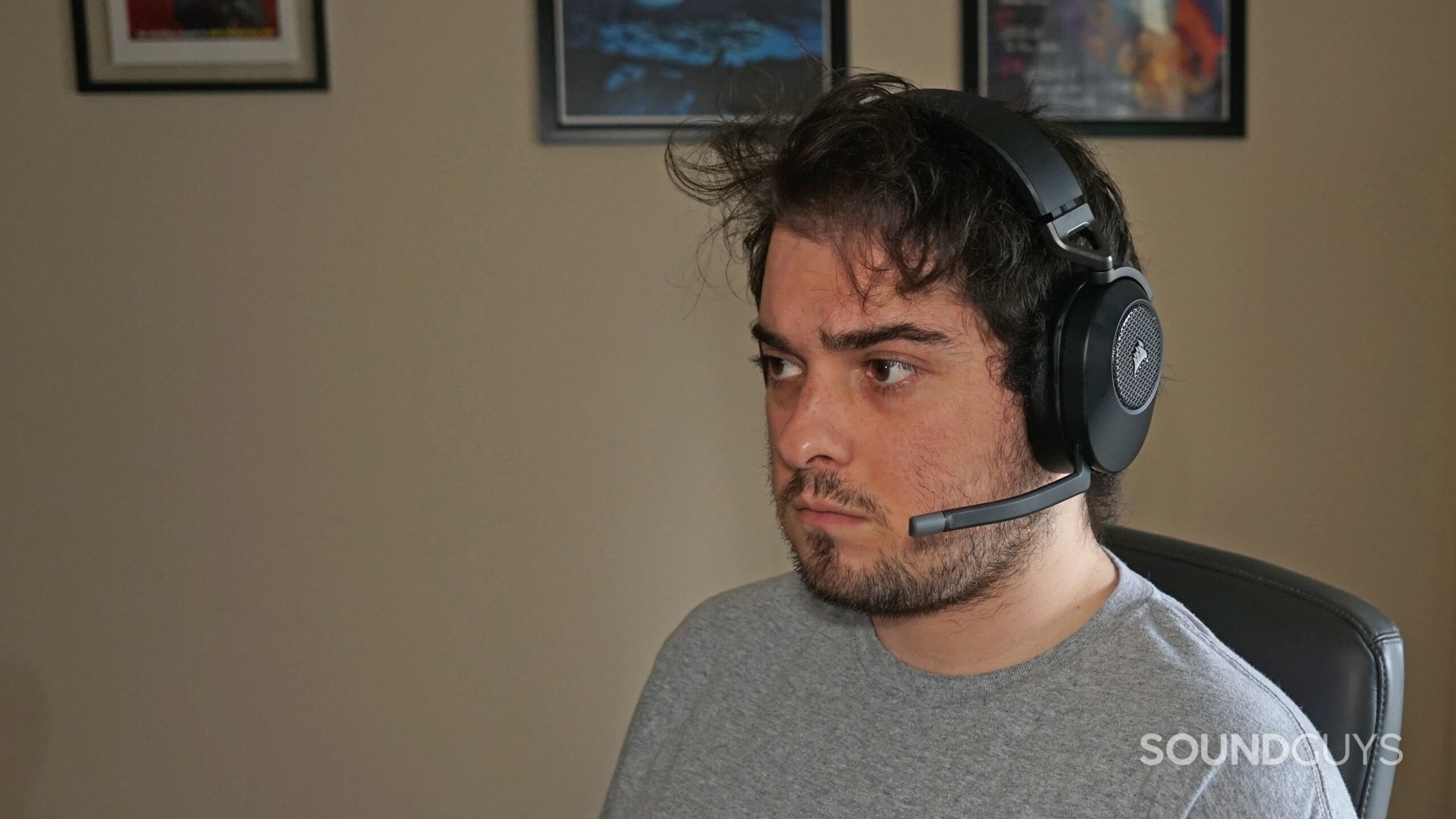 A man wears the Corsair HS65 Wireless sitting at a desk.