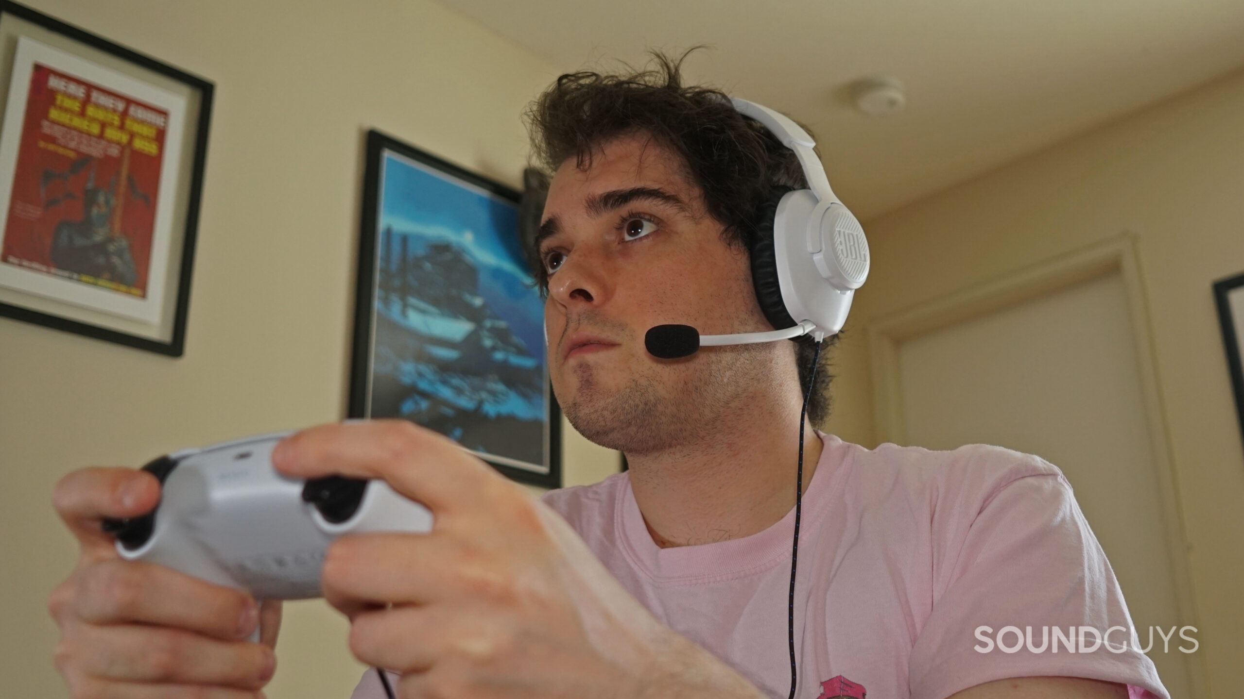 A man sits holding a PlayStation DualSense controller.
