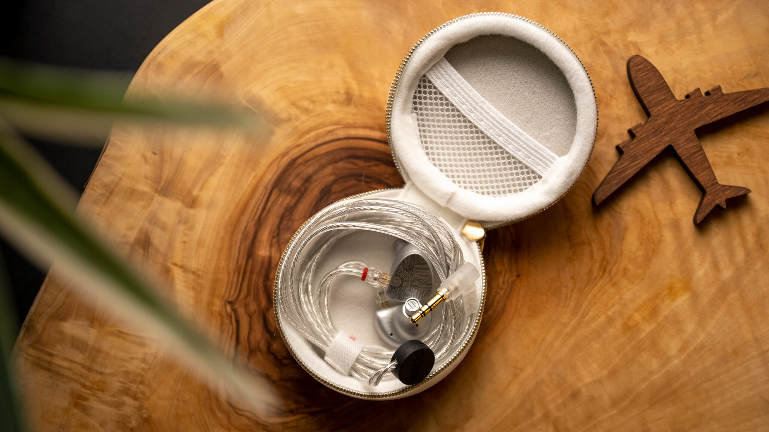 The Moondrop Aria SE sitting inside its carrying case on top of a wooden table.