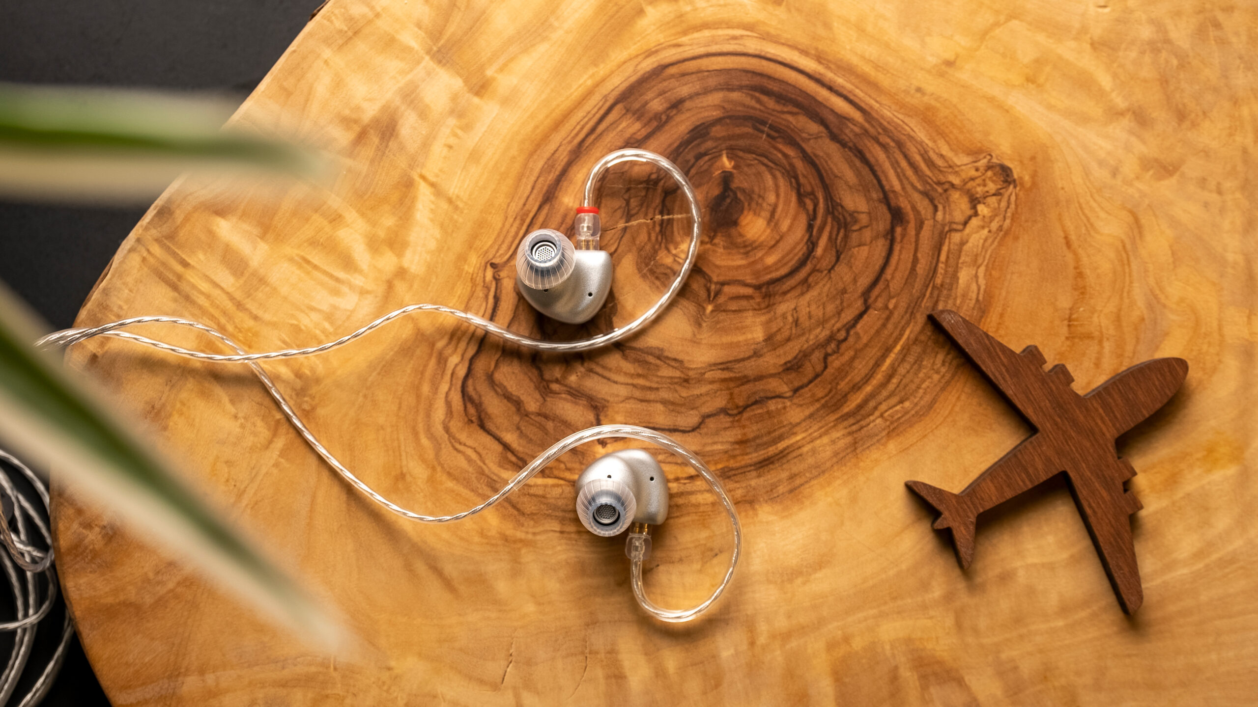 The Moondrop Aria SE sitting on a wooden table with knick knacks surrounding it.