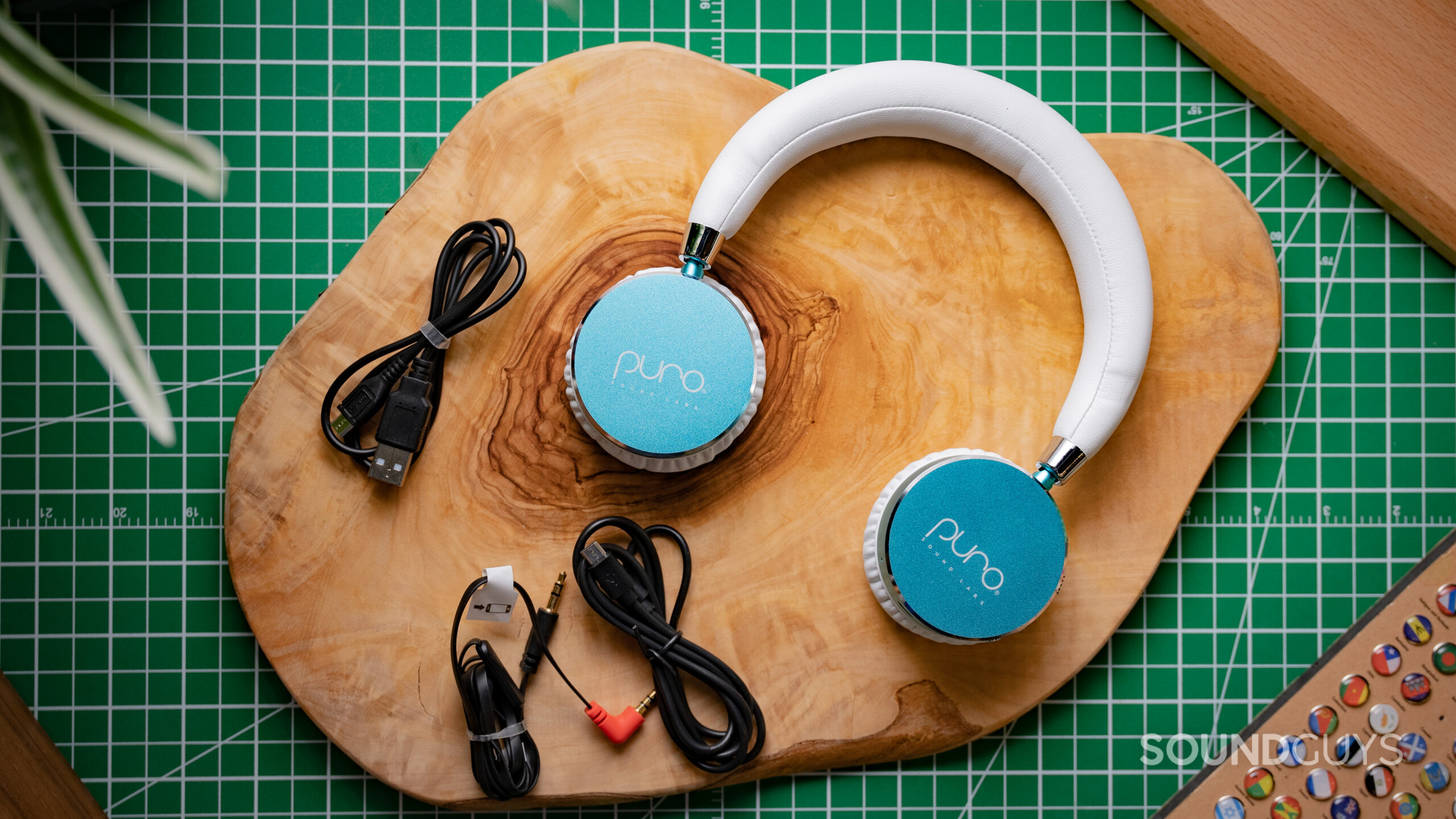 A photo of the Puro Sound Labs BT2200 sitting atop a wood slab, with its charging cable,