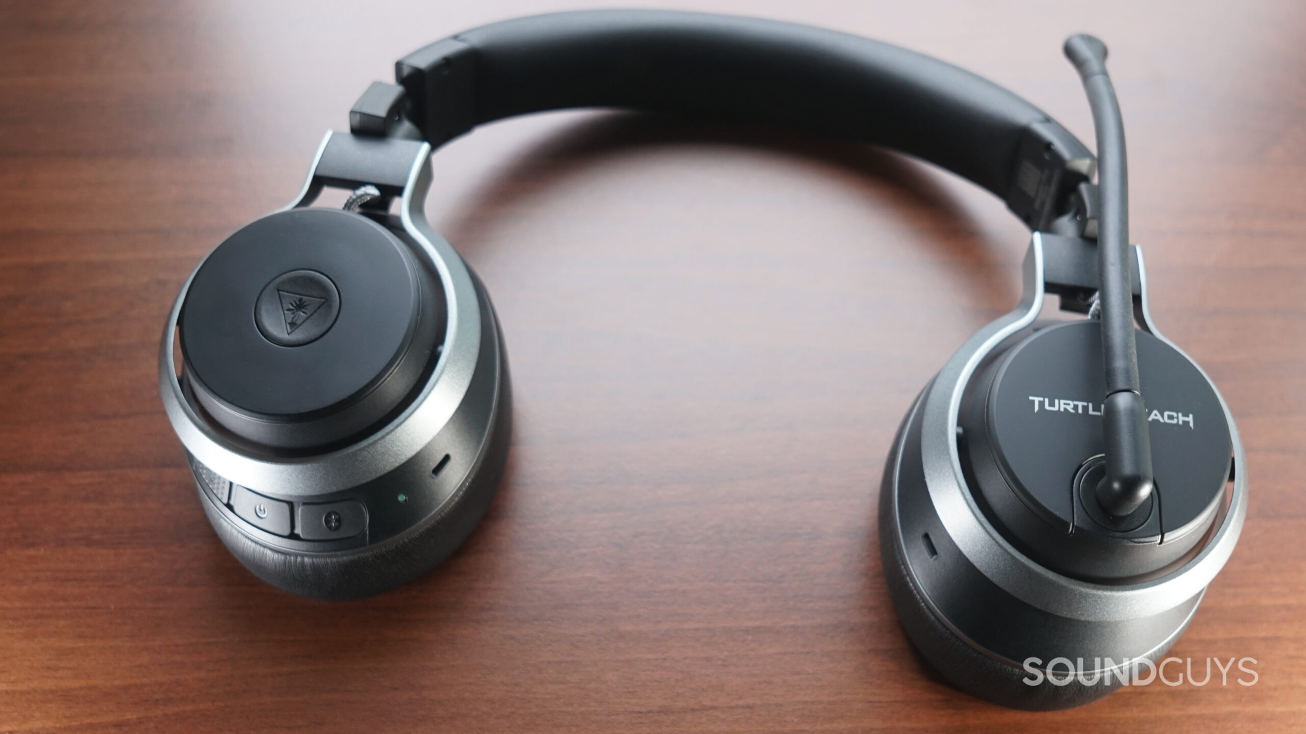 The Turtle Beach Stealth Pro gaming headset lays flat on a wooden surface.