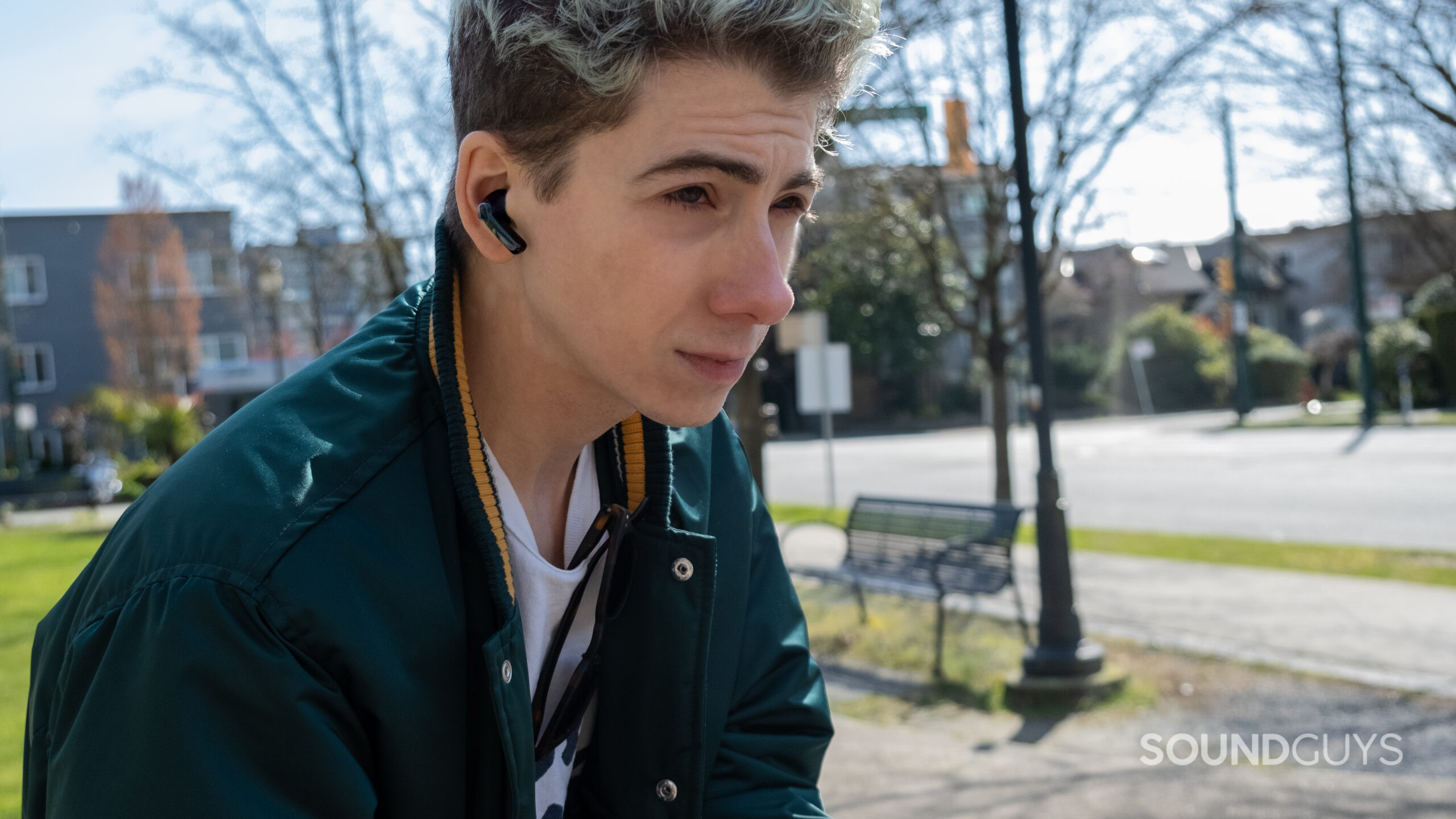 In a park a man looks to the right while wearing the TOZO NC2.