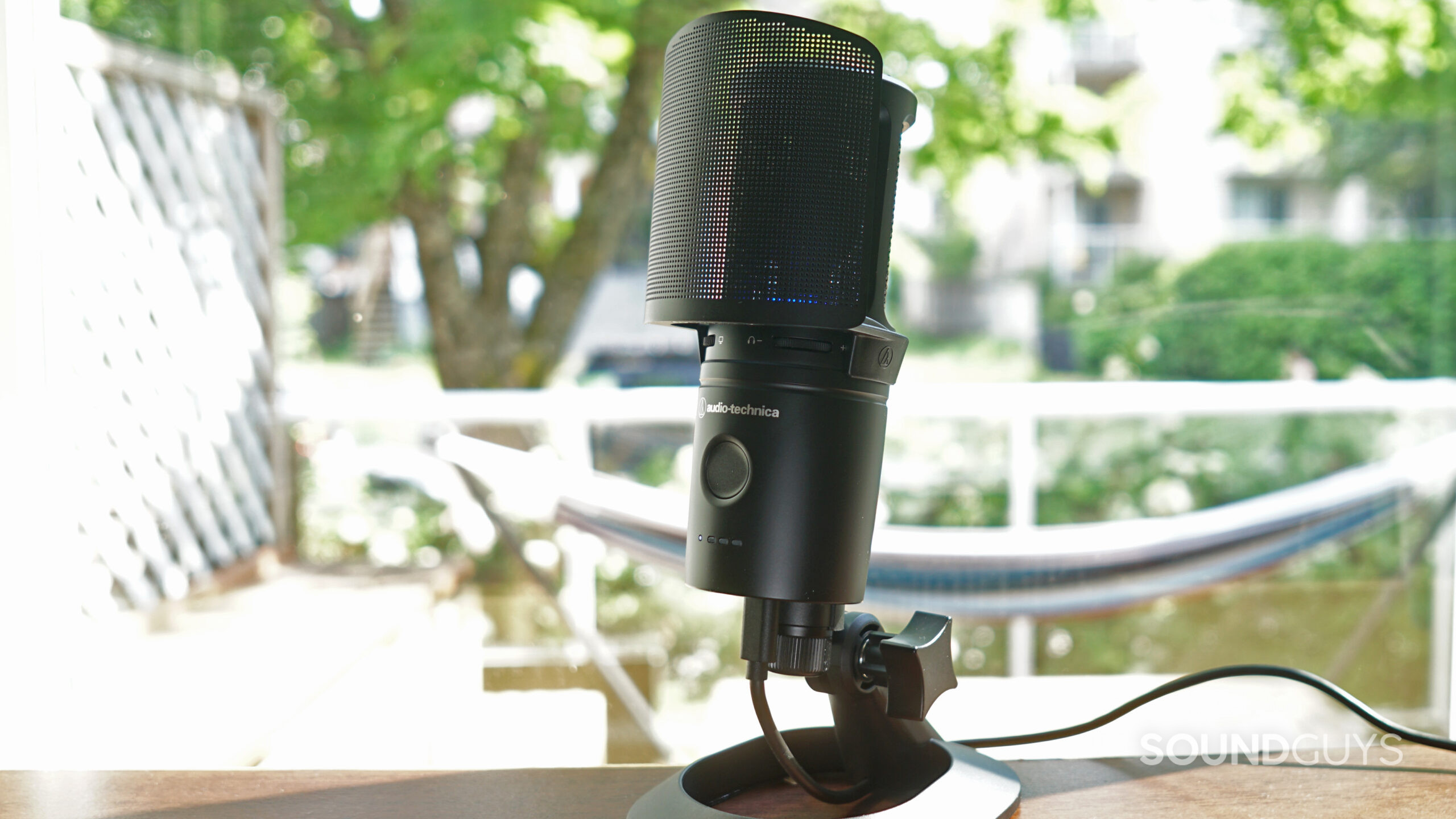 The AT2020USB-XP microphone sitting on a desk with the pop filter and stand placed on it.