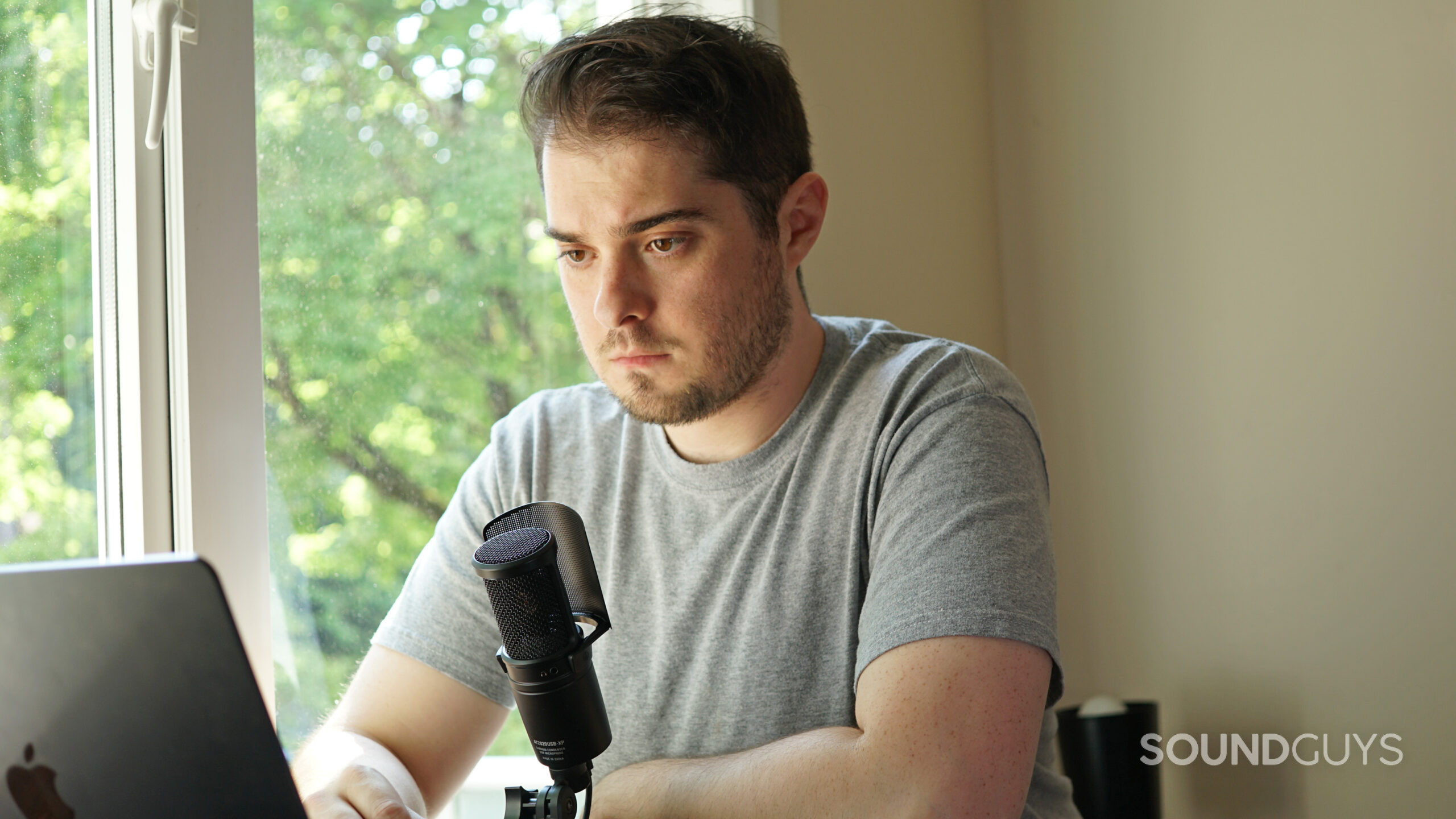 The AT2020USB-XP on a desk with a person in front of it.