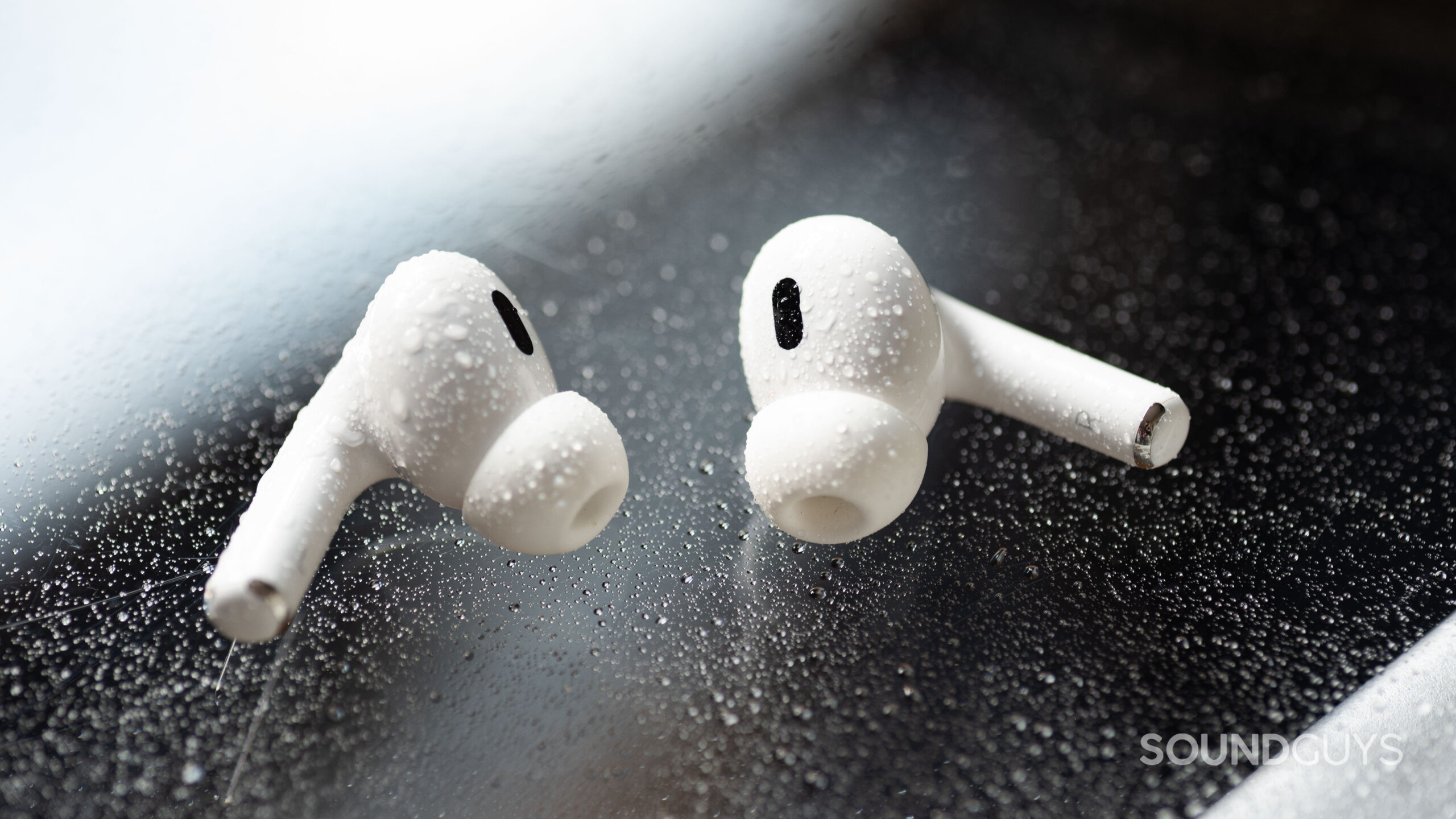 The AirPods Pro 2 with water droplets on them.