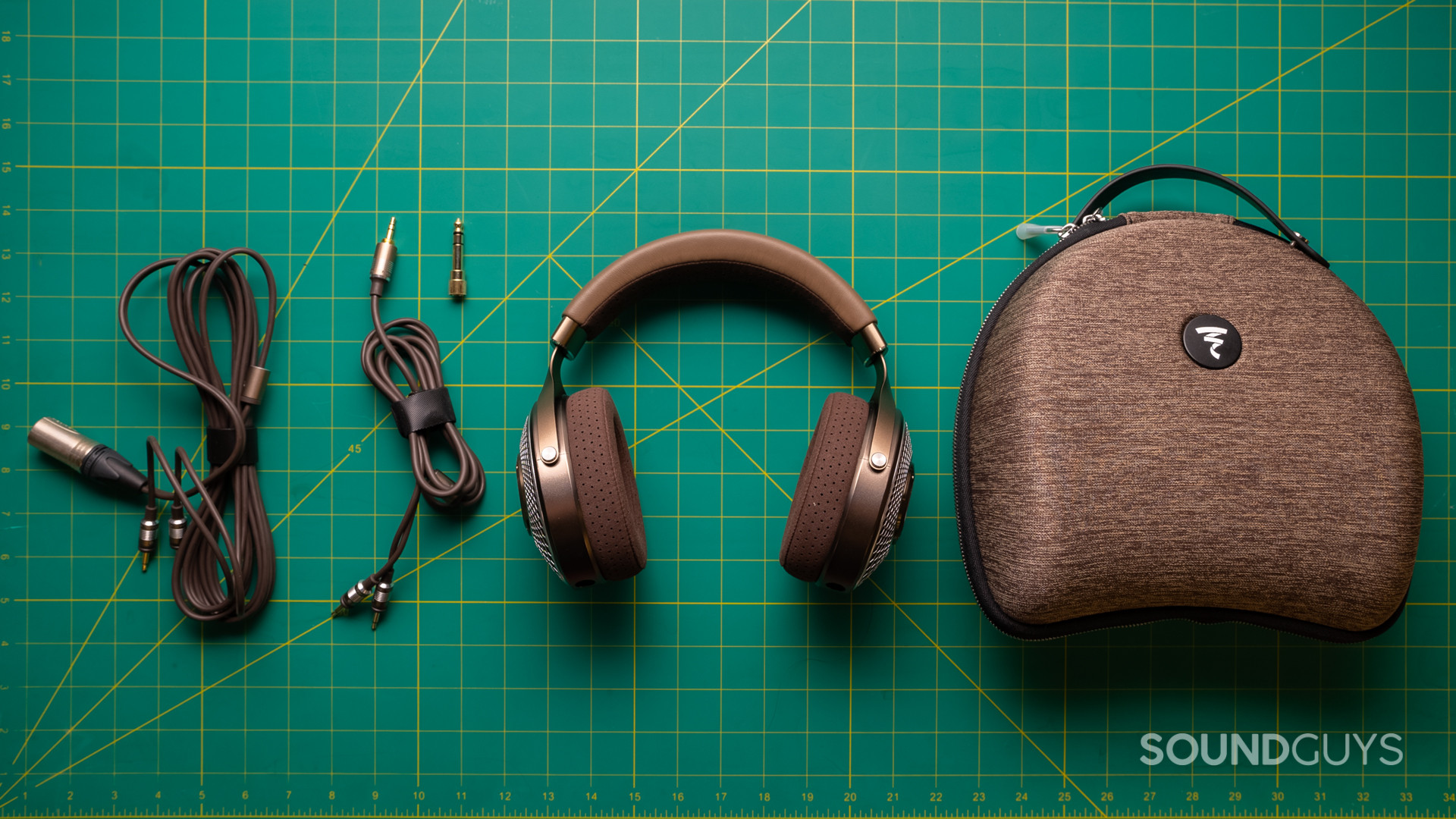 A photo of the Focal Clear MG on a fabric cutting board with all accessories laid out upon it.