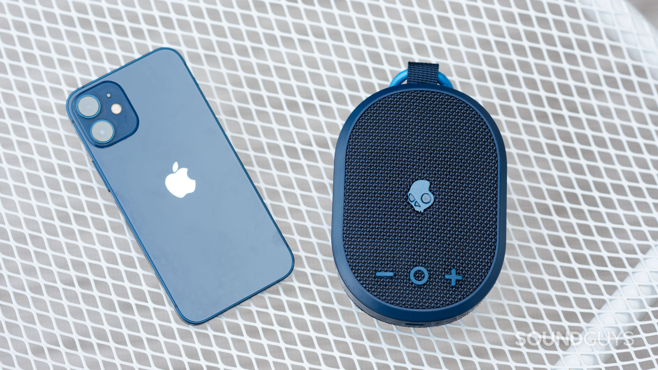 The Skullcandy Kilo next to an iPhone 12 mini; both products are in blue.