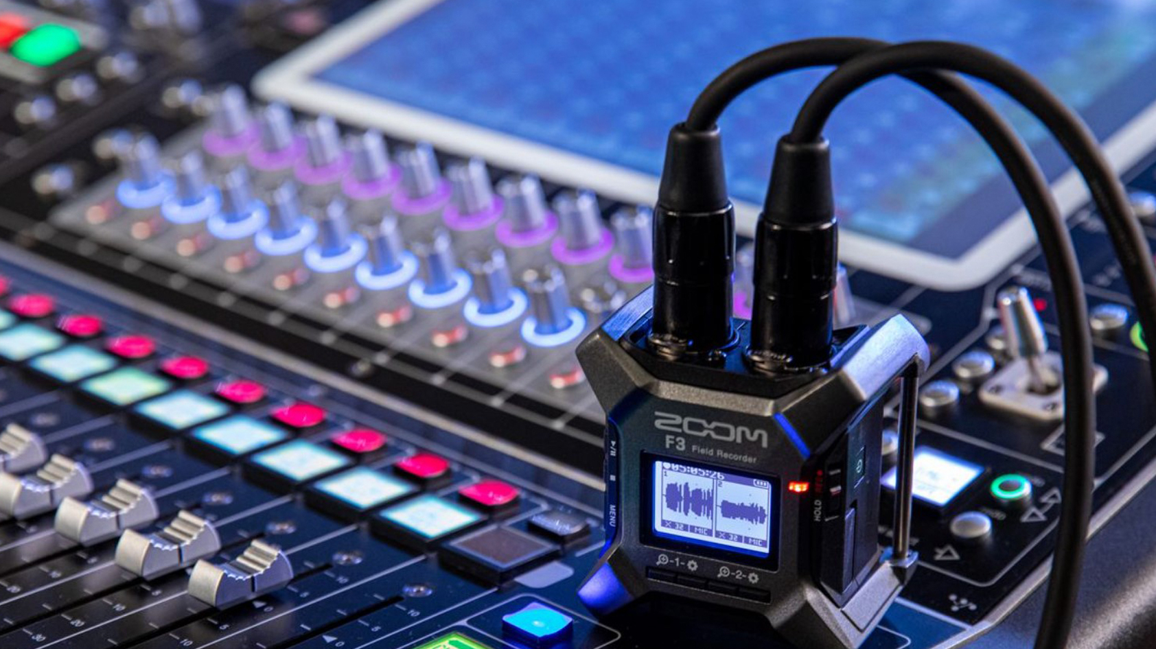 The Zoom F3 Field Recorder sits on a mixing board with two XLR cables connected.