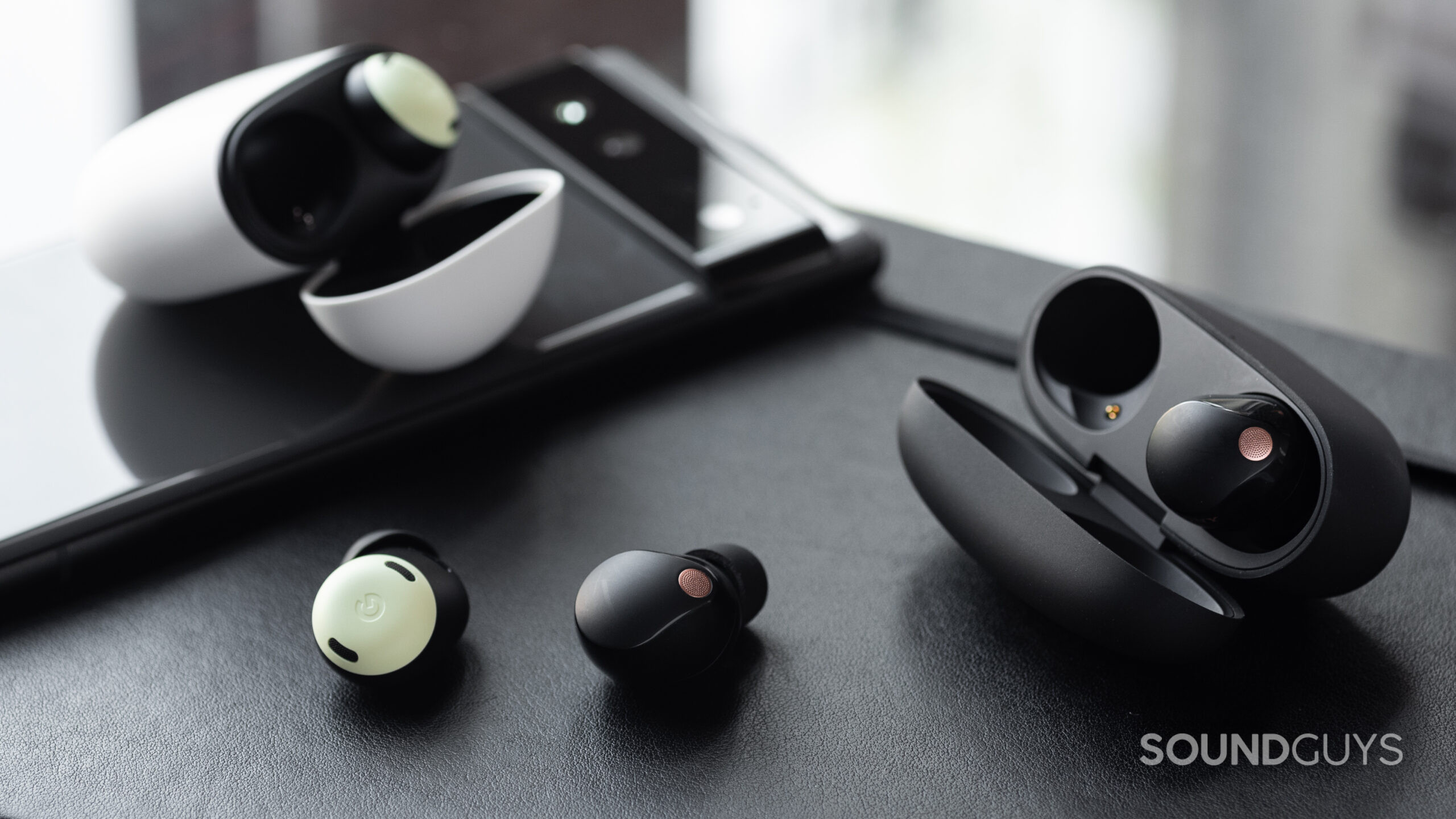 The Pixel Buds Pro and WF-1000XM5 with one earbud out of each case.