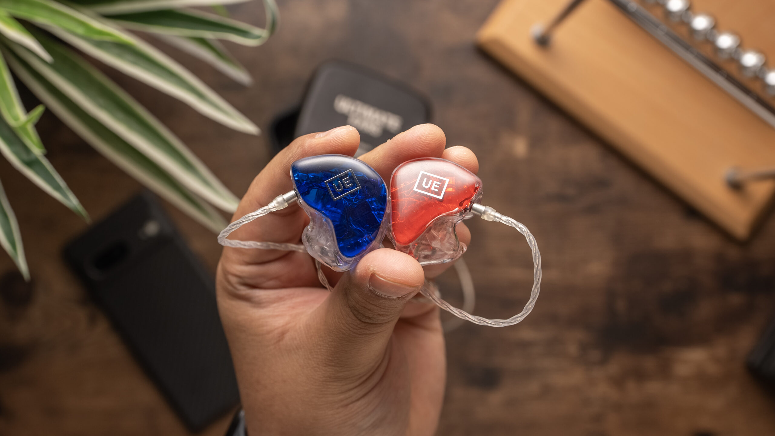 Ultimate Ears UE Premier left and right units held in fingers.