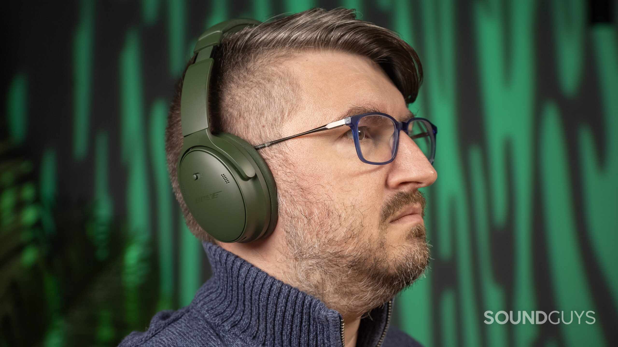 a man wearing the green Bose QuietComfort Headphones