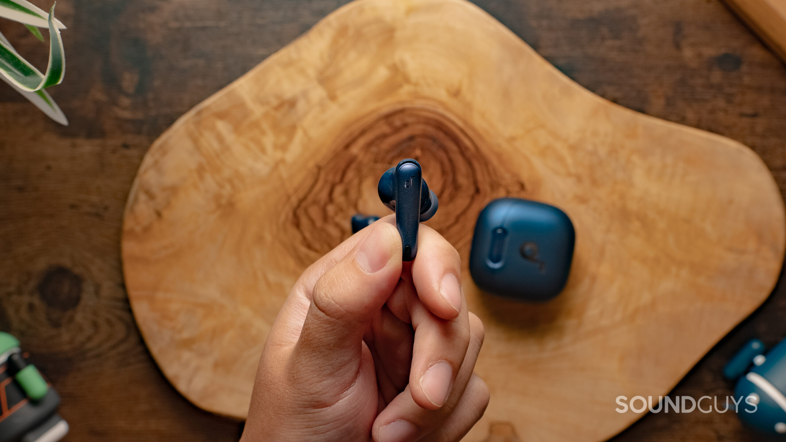 A hand holds the Anker Soundcore Liberty 4 NC earbud showing the outer angle.