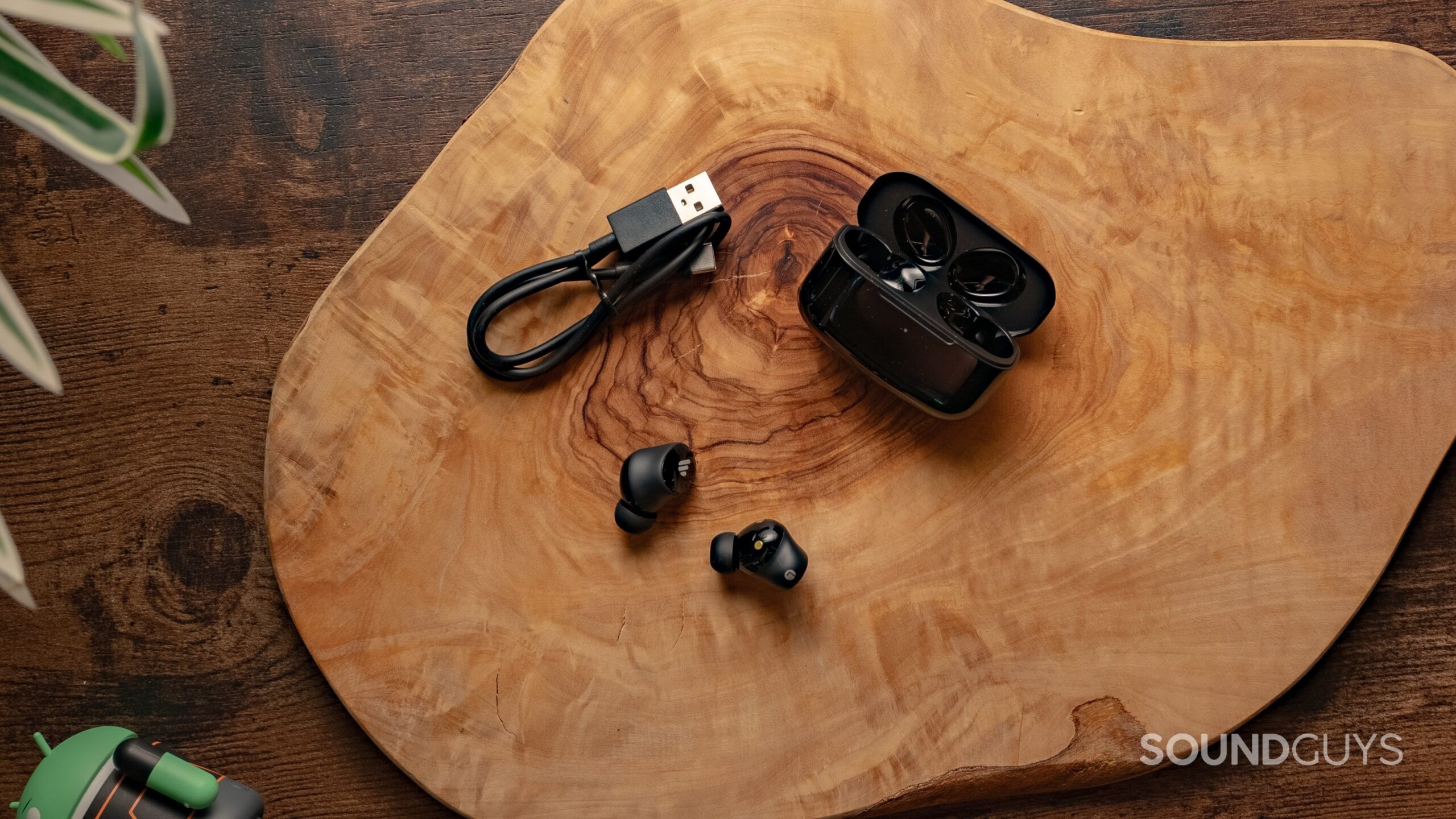 Edifier TWS1 Pro 2 earbuds, case, and charging cable on wood table.