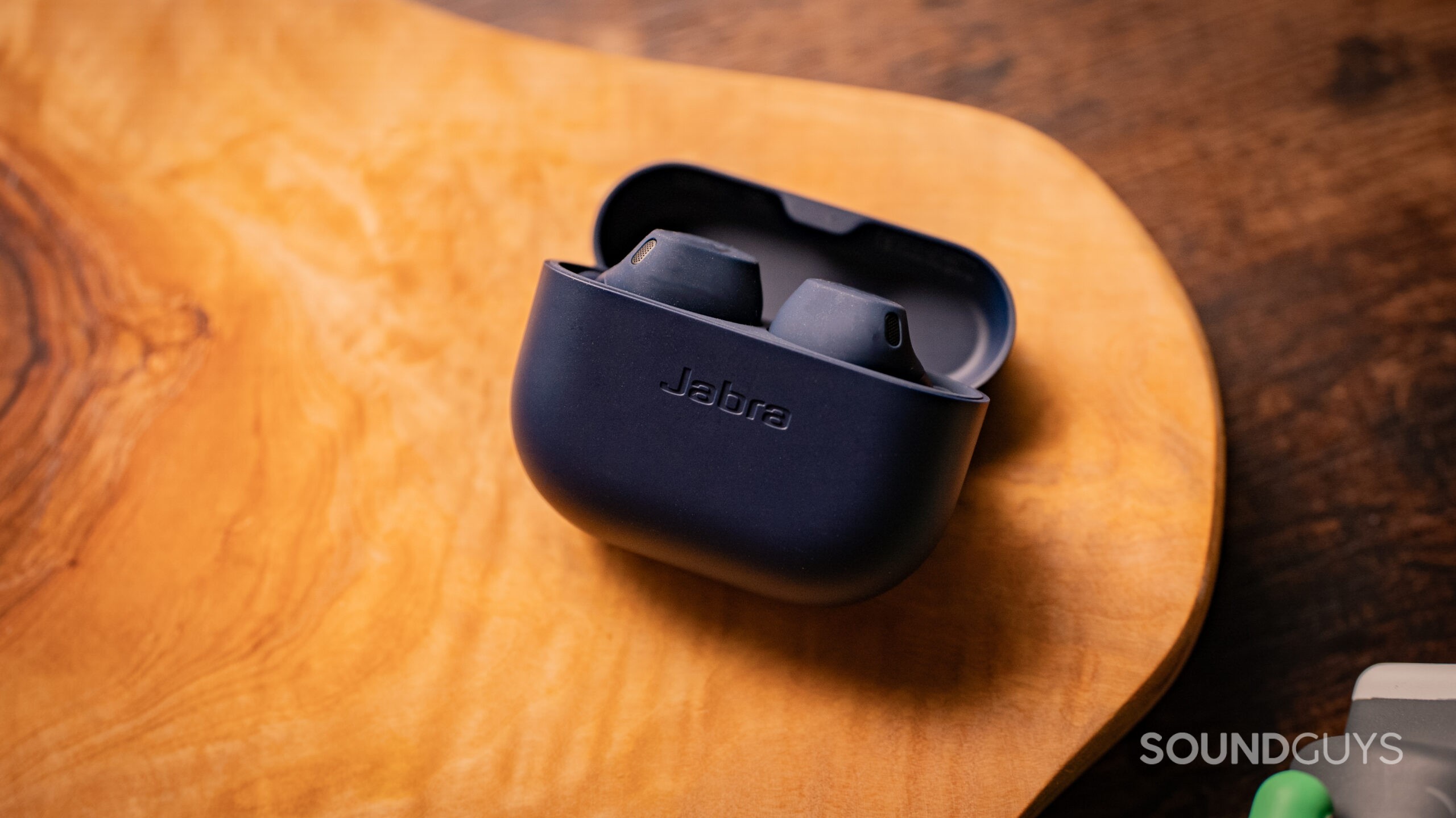 The Jabra Elite 8 Active shown with the lid open propping up the case.