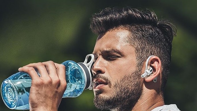 a man drinking from a water bottle while wearing the elago ear hooks on his airpods