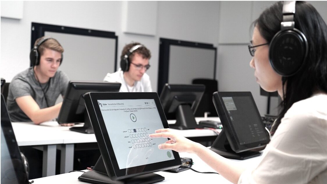 3 people are wearing headphones, participating in a controlled listening test.