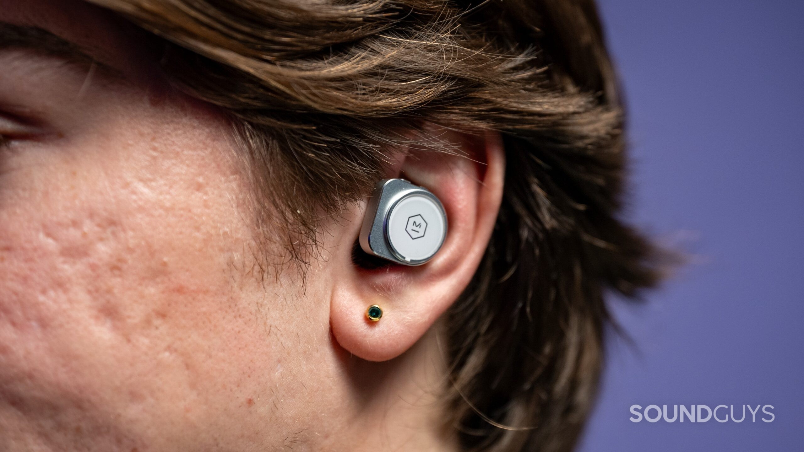 Master &amp; Dynamic MW09 earbuds in a human ear. 