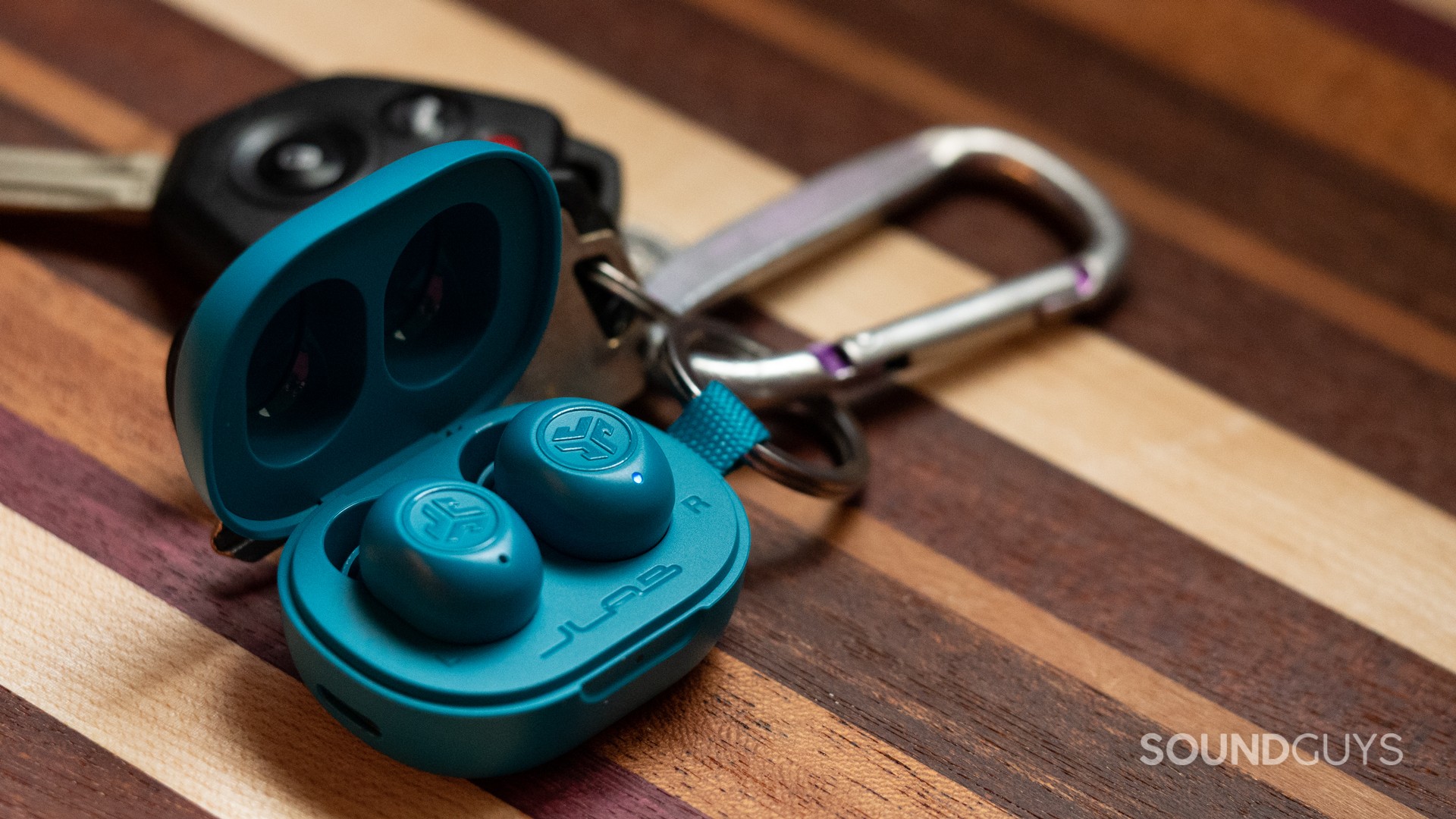 A photo of the JLab JBuds Mini attached to a set of keys.