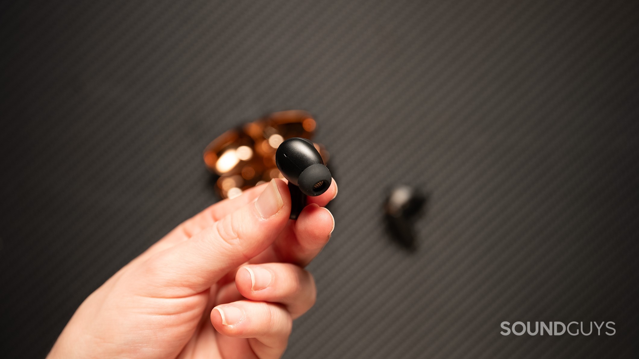 Creative Aurvana Ace 2 earbud held in a hand.