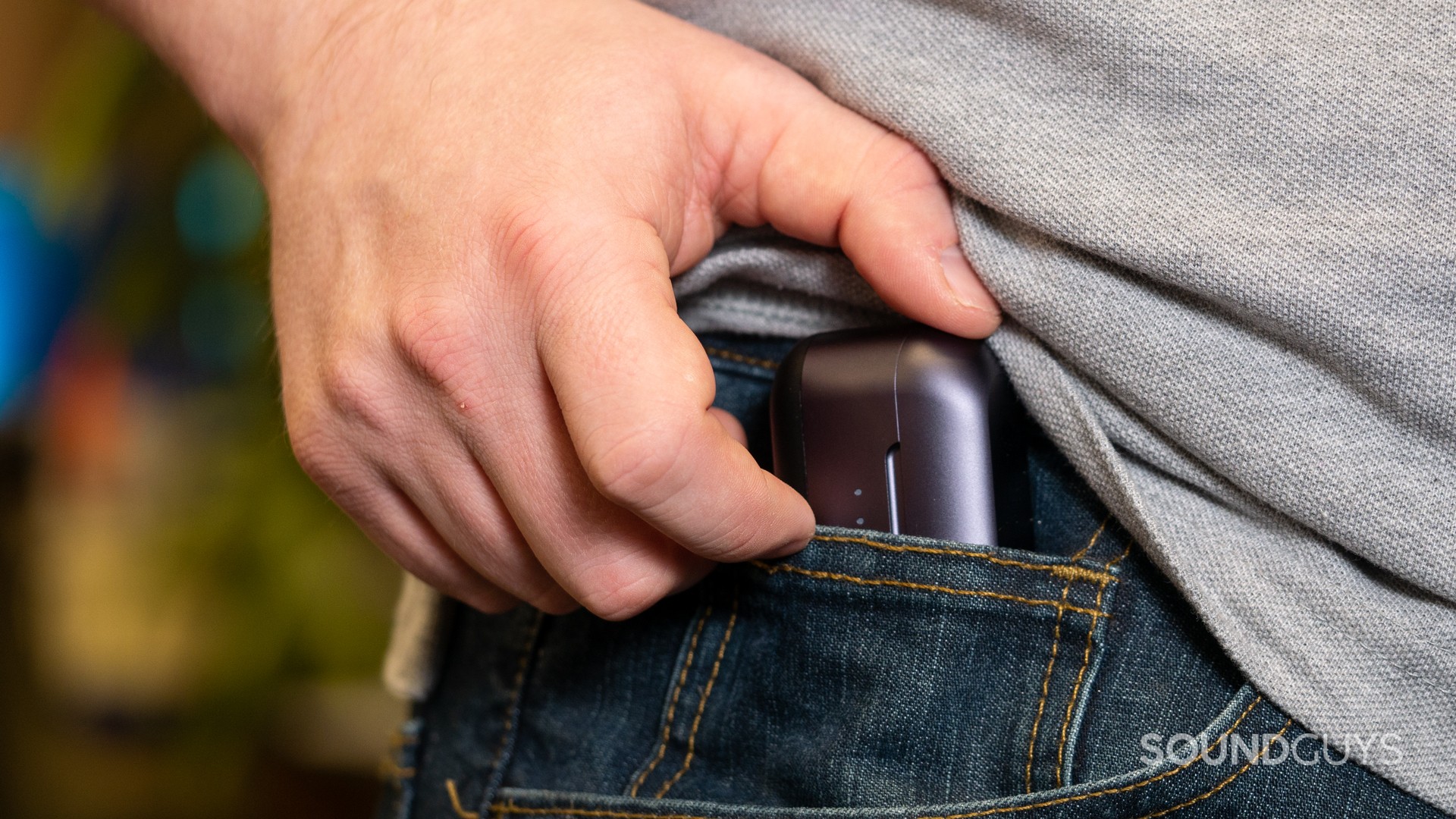 A photo of a man shoving the JLab Epic Lab Edition into his pocket.