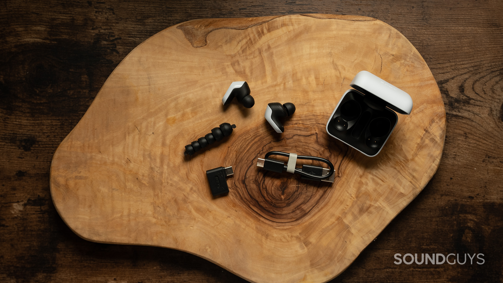 Sony INZONE Buds on a table with all of their accessories including ear tips and charging cable. 