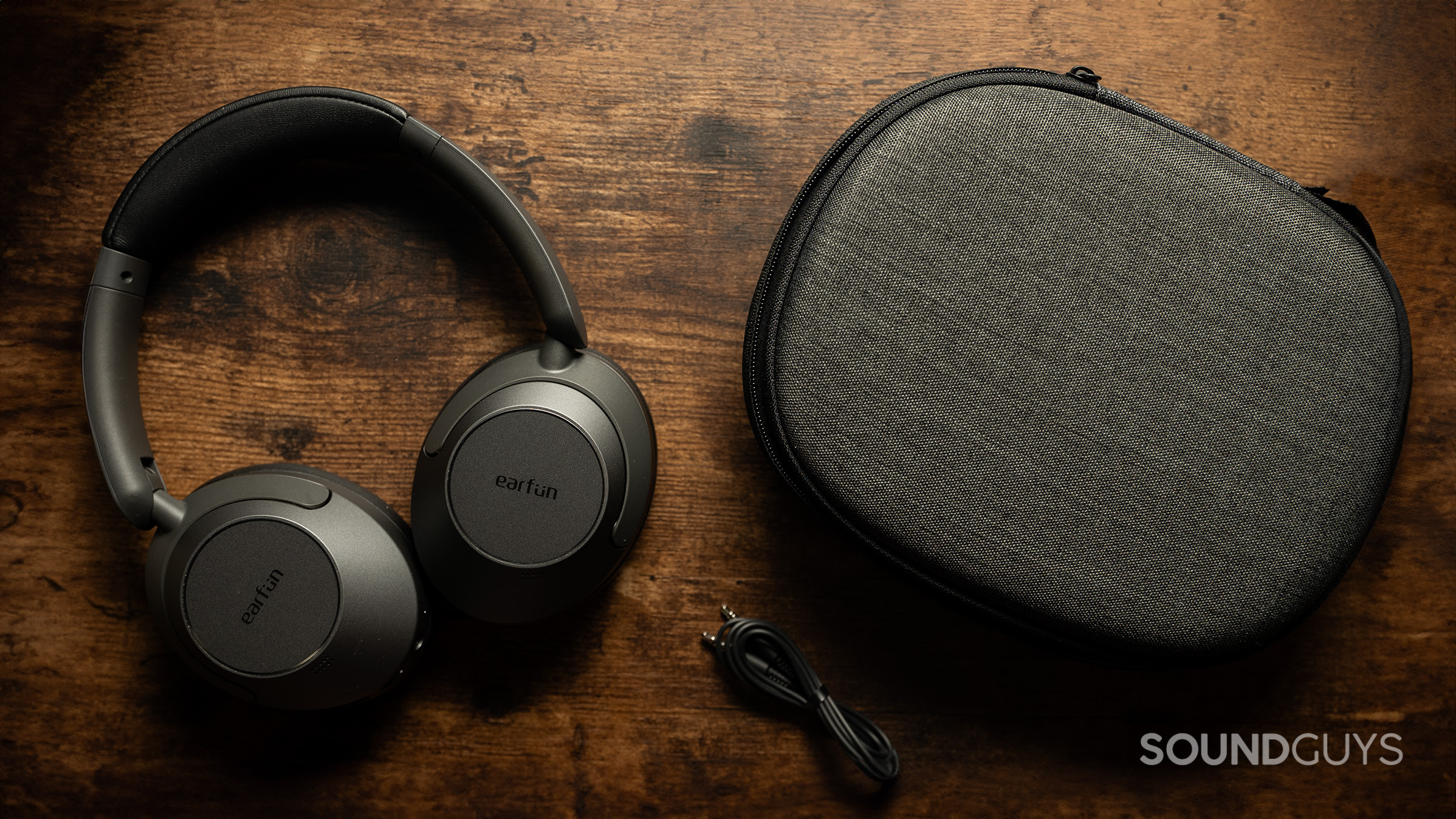 The EarFun Wave Pro headphones next to an audio cable and headphone case. 