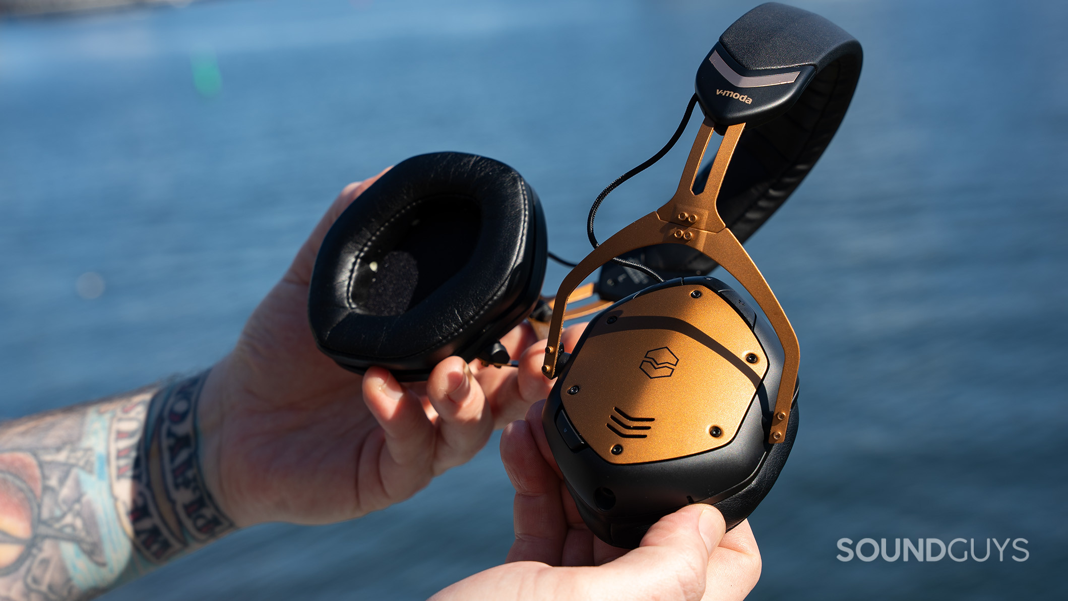 The V-MODA Crossfade 3 Wireless headphones are bent over a body of water. 