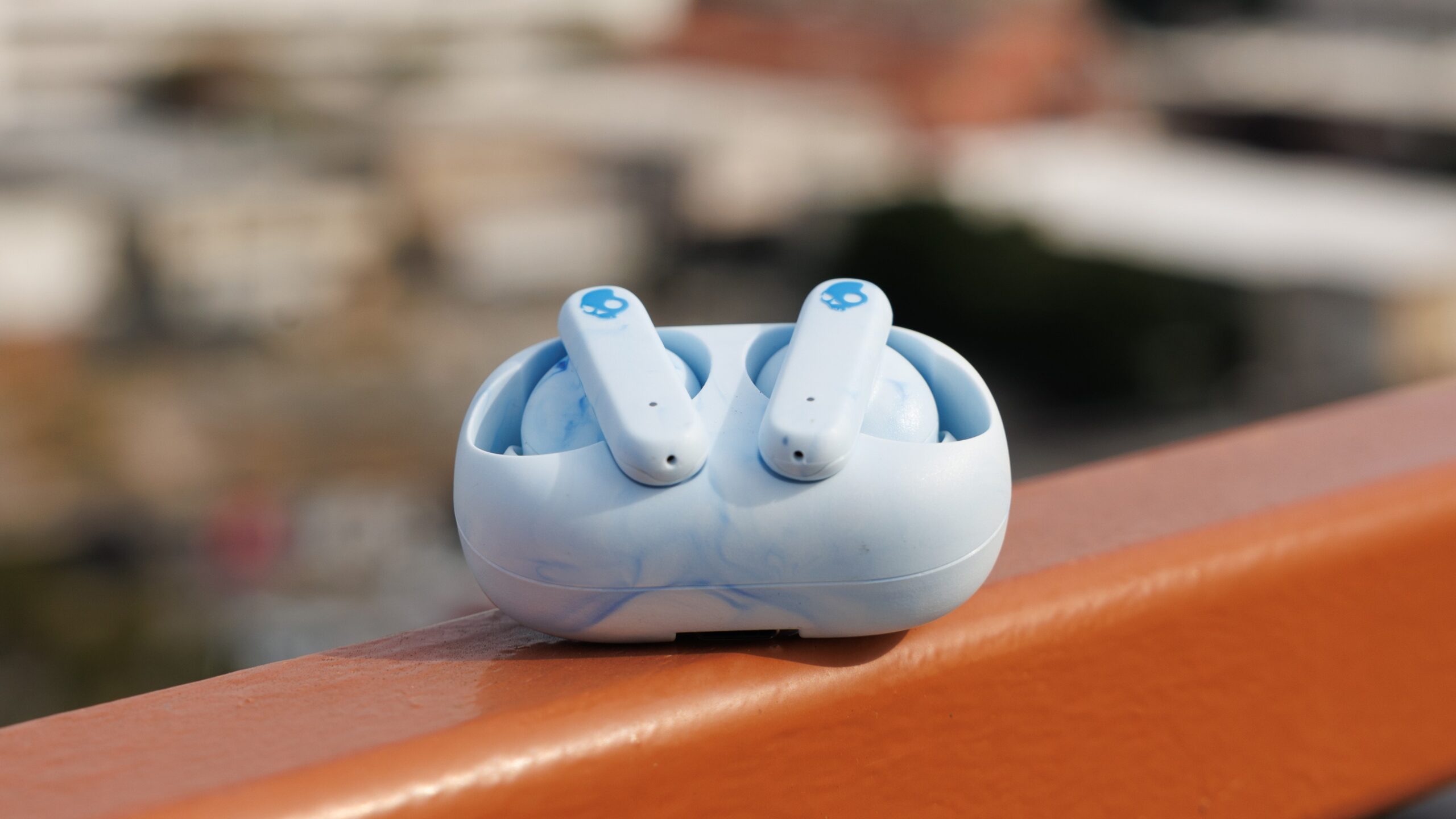 skullcandy ecobuds sitting on a railing