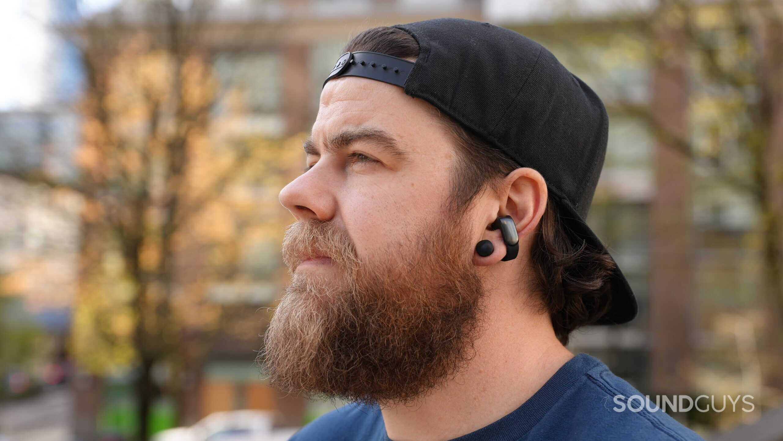A man wearing the Bose Ultimate Open Earbuds looking off into the distance.