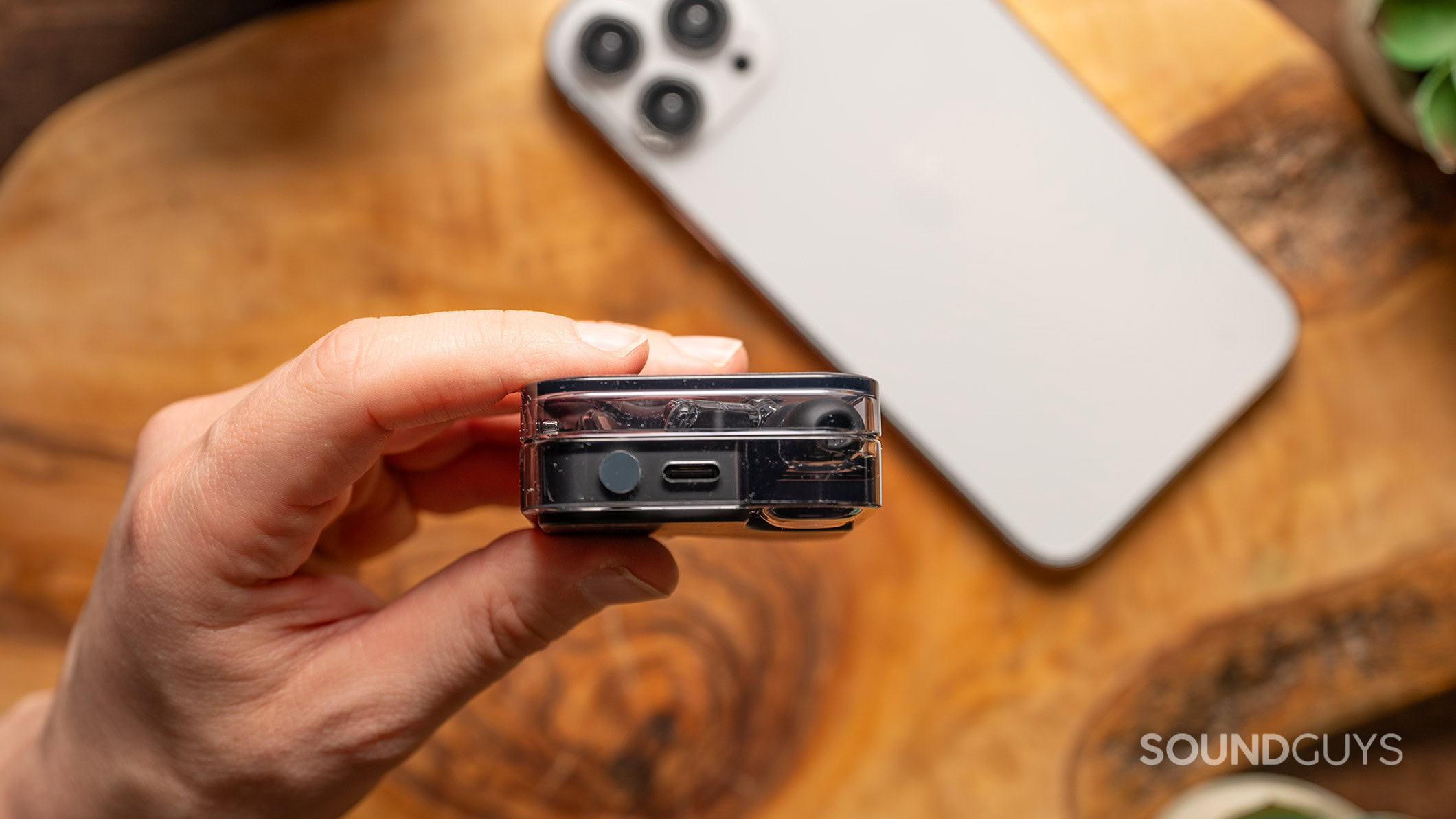 A hold holds the Nothing Ear charging case showing the USB-C port. 