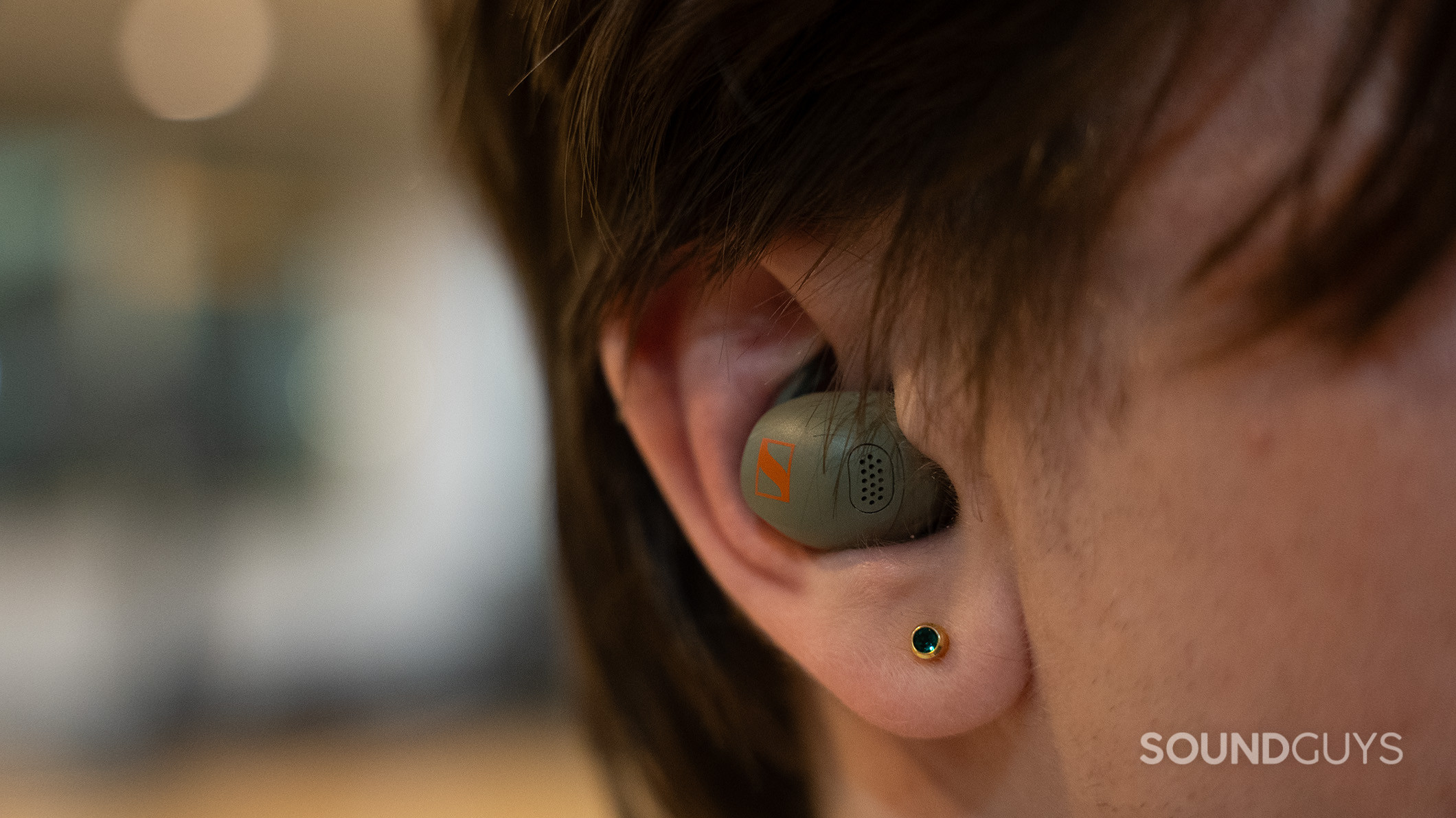 A Sennheiser MOMENTUM Sport earbud inside an ear. 