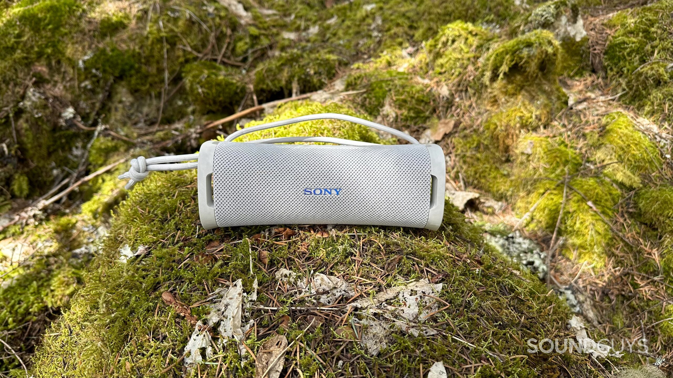 Front facing view of the Sony ULT Field 1 on a mossy rock.