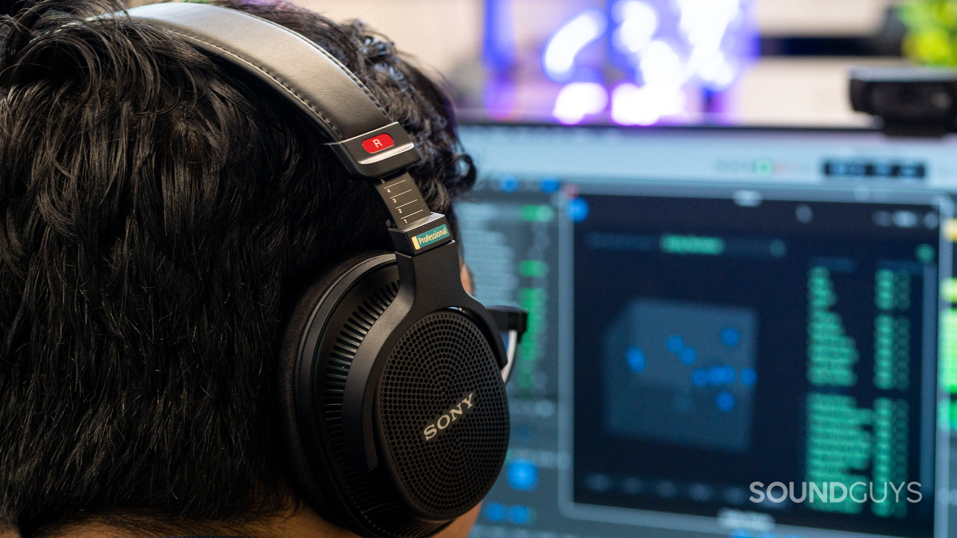 A photo of a man wearing the Sony MDR-MV1 while editing spatial audio tracks.